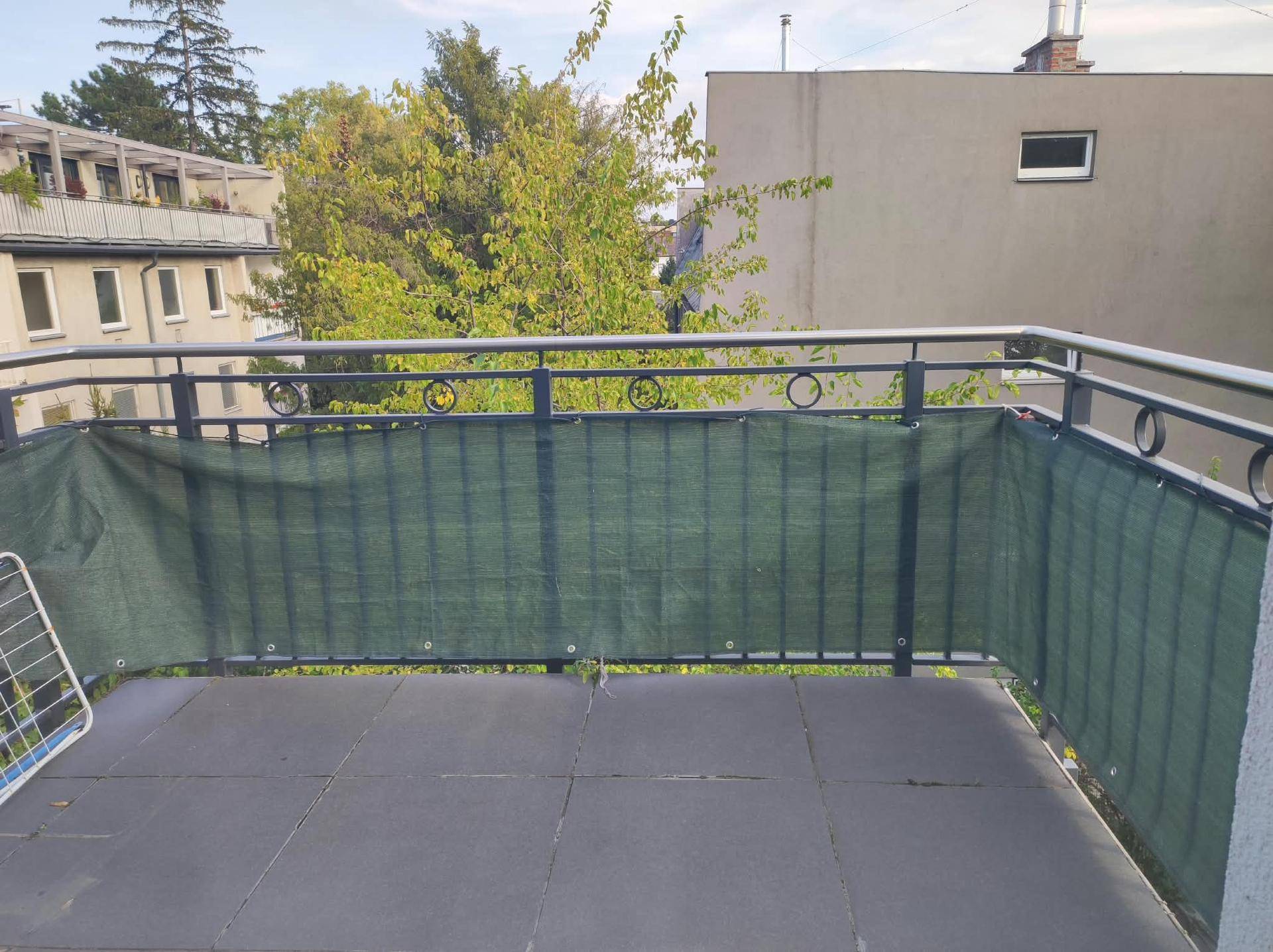 Geräumiger Balkon mit Metallgeländer und Sichtschutz, bietet Platz zum Entspannen.