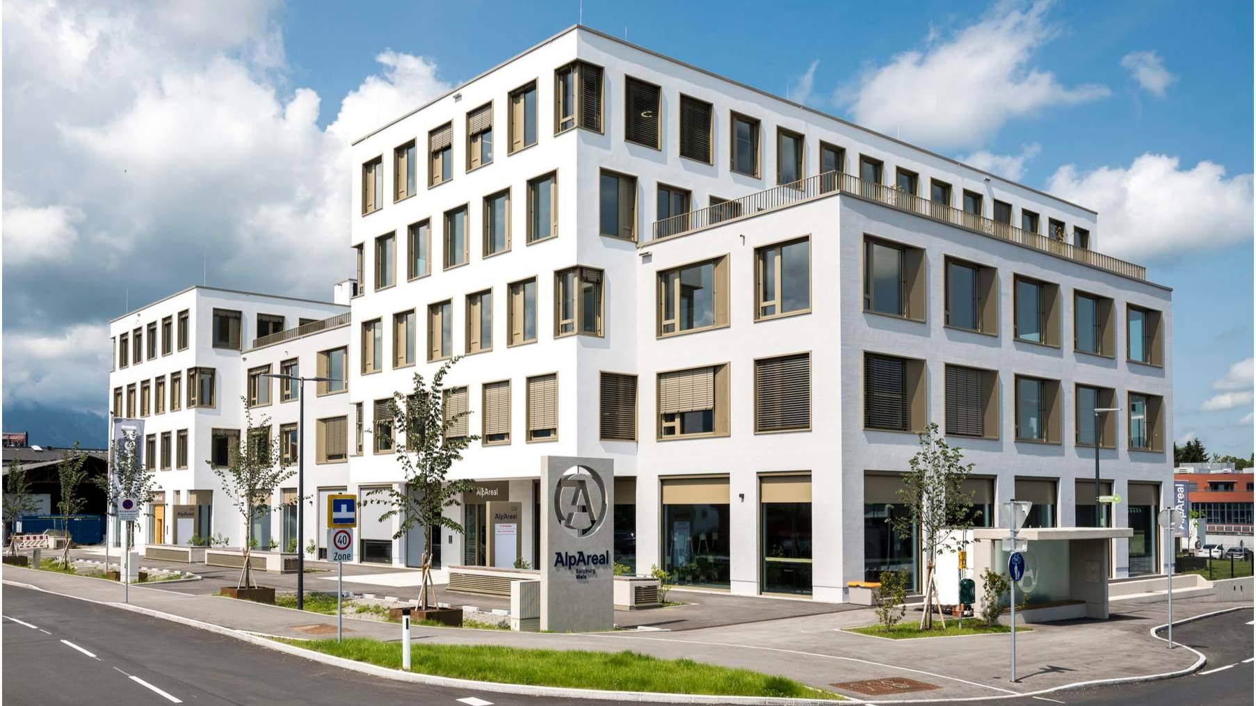 Ansicht des modernen Bürogebäudes mit klarer Architektur und vielen Fenstern unter blauem Himmel.
