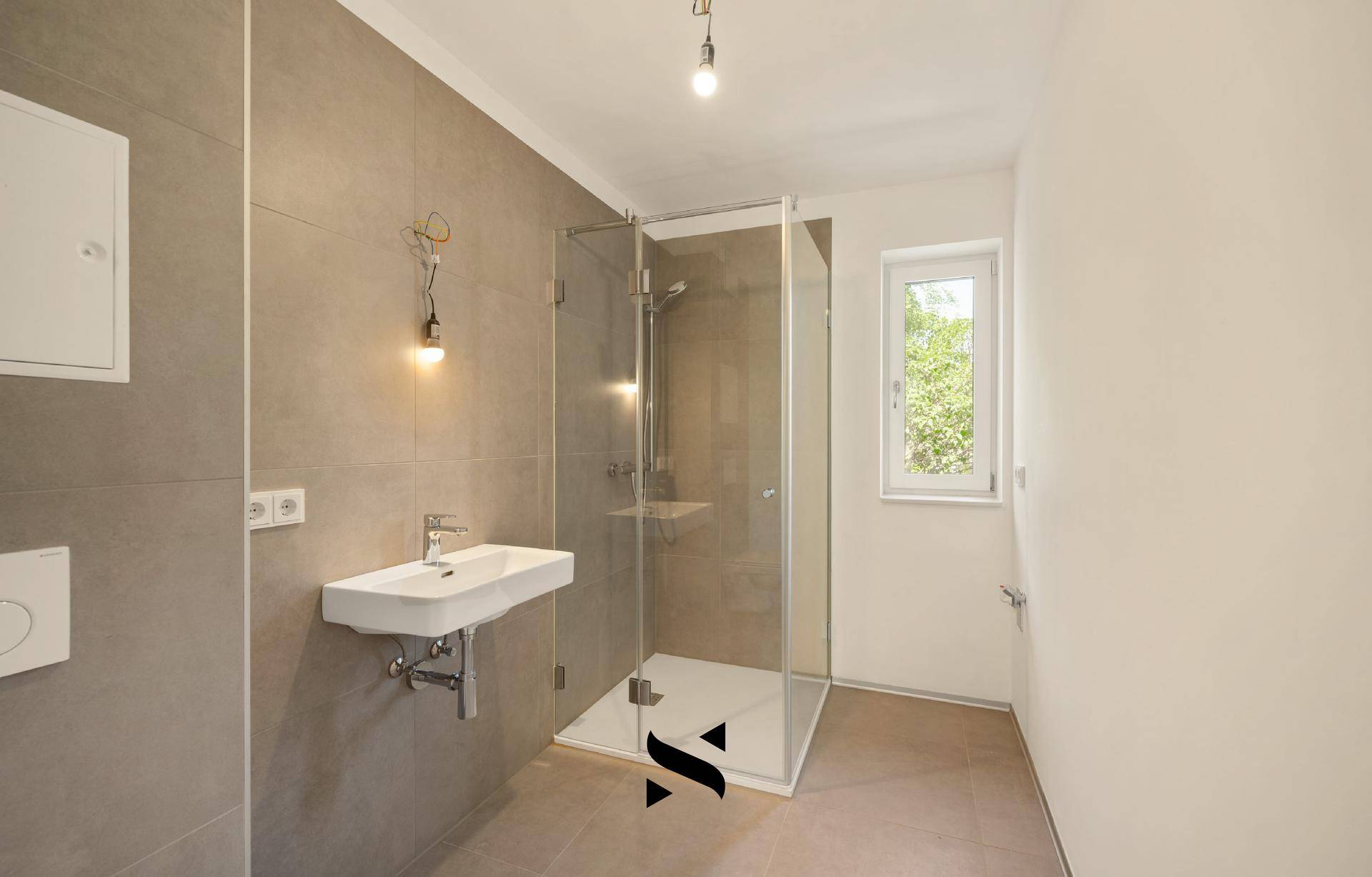 Modernes Badezimmer mit großer Duschkabine, Waschbecken und einem Fenster für Tageslicht.