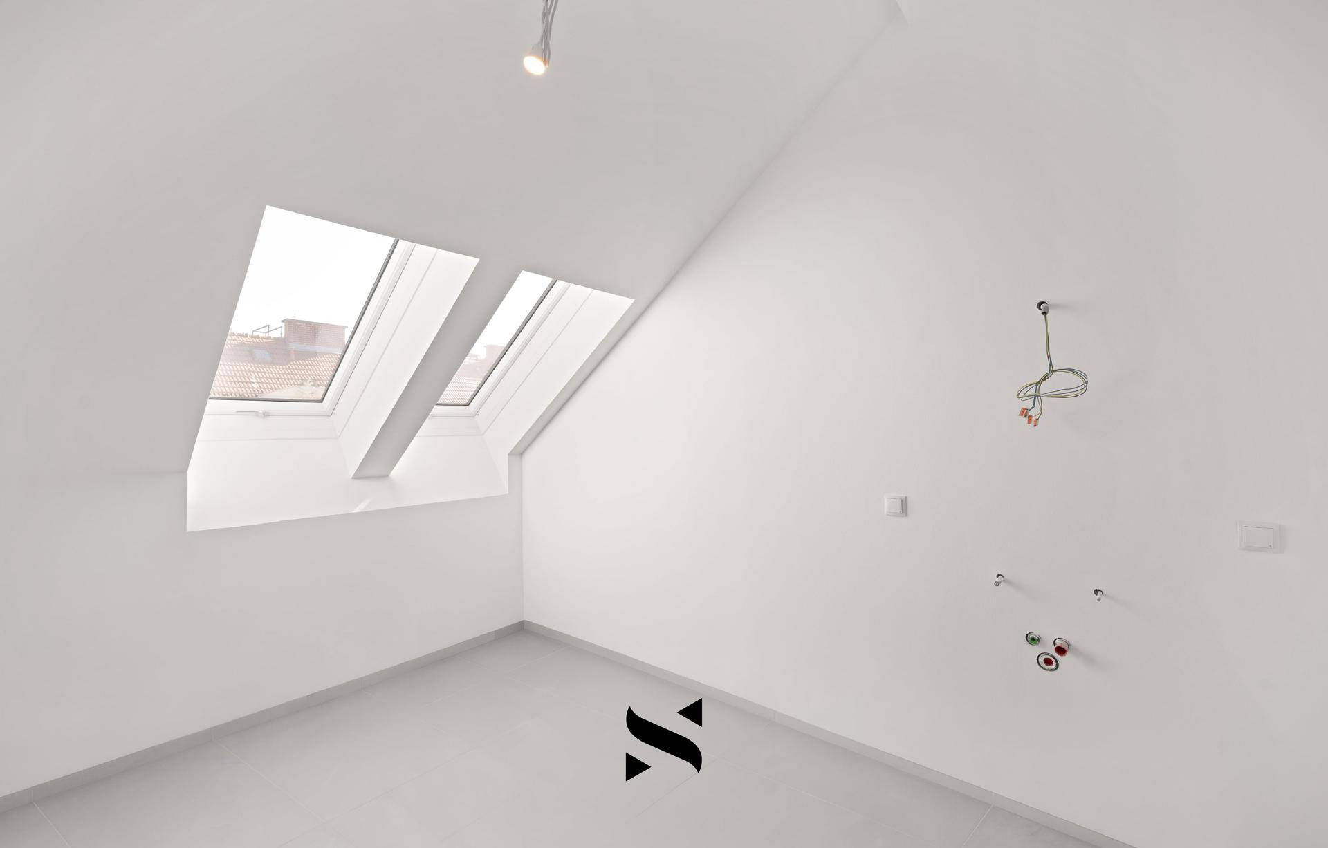 Raum mit Dachschrägen, Dachfenstern und vorbereiteten Anschlüssen für Installationen.