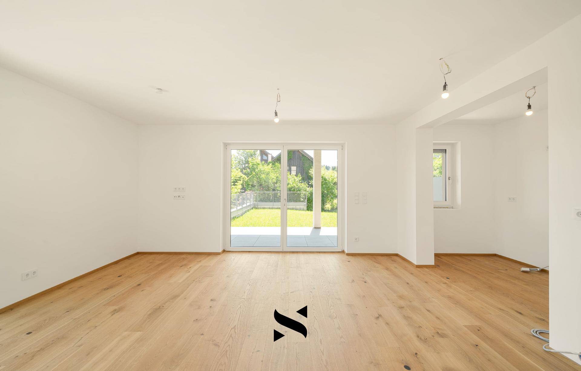 Geräumiges, helles Zimmer mit Holzboden und Zugang zu einem privaten Gartenbereich.