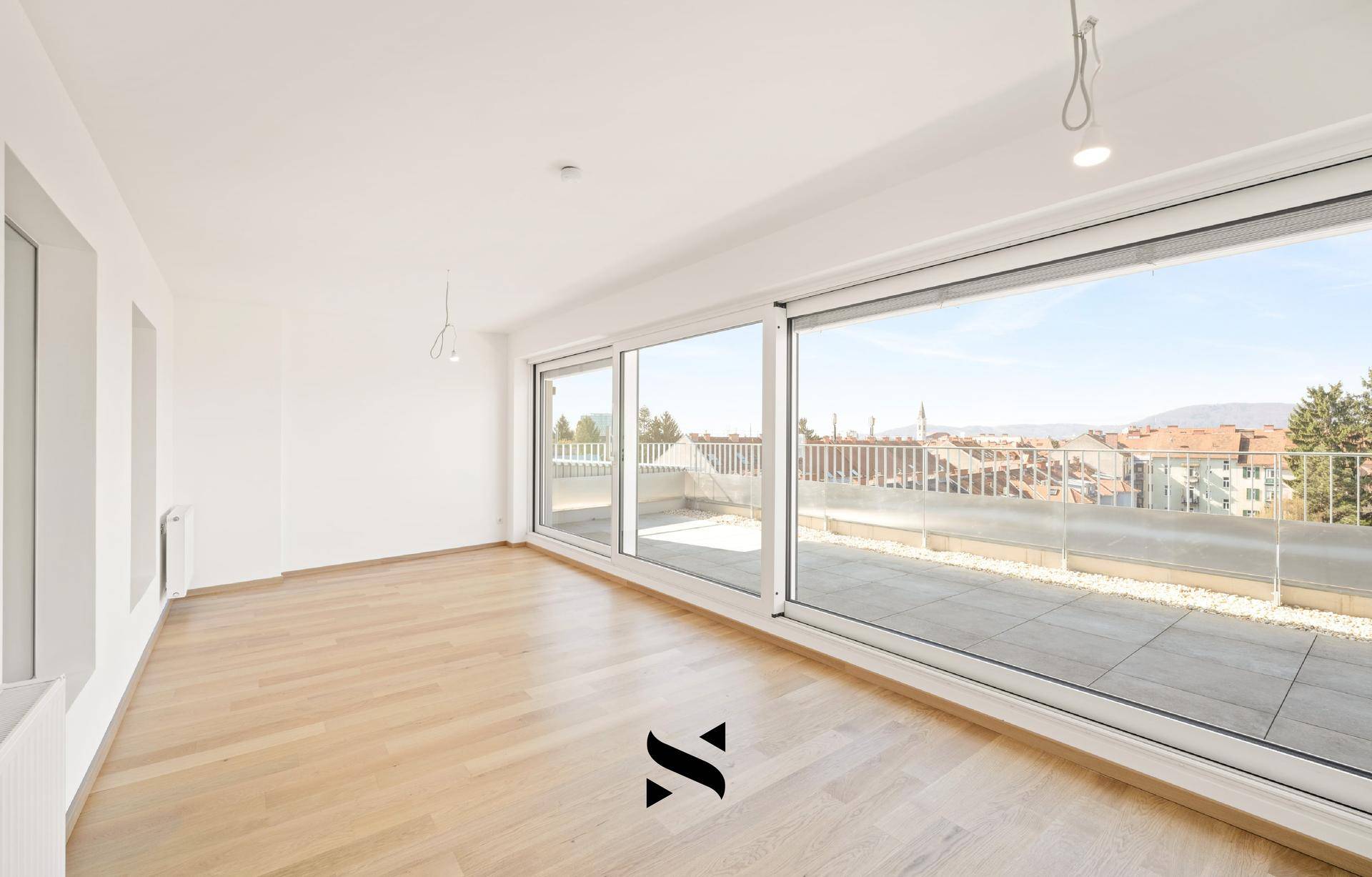Geräumiger Wohnraum mit Parkettboden und raumhohen Fenstern mit Blick auf die Stadt.