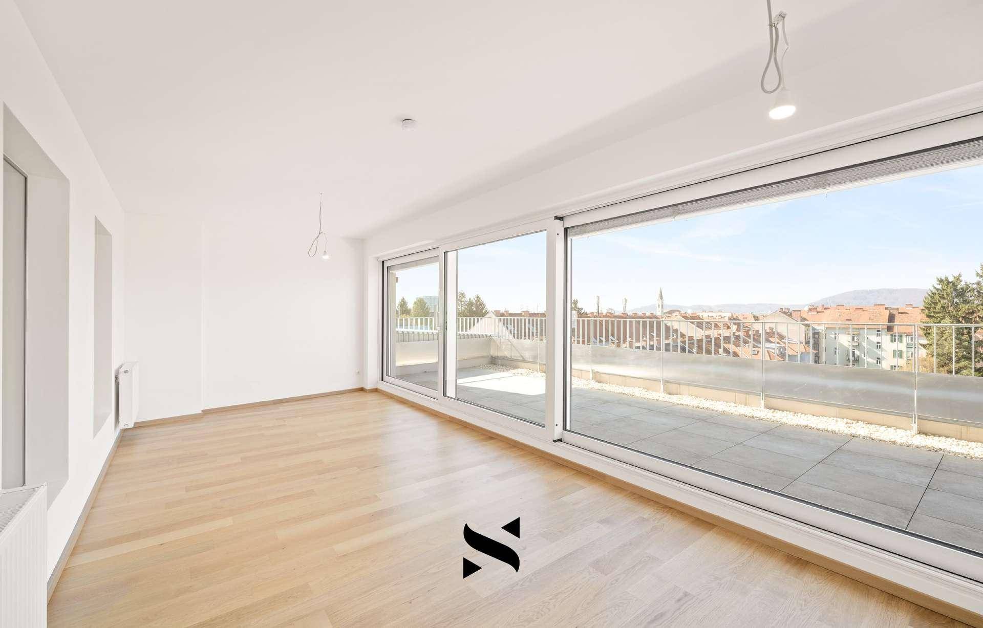 Geräumiger Wohnbereich mit Holzparkett und Panoramafenstern zur Dachterrasse.