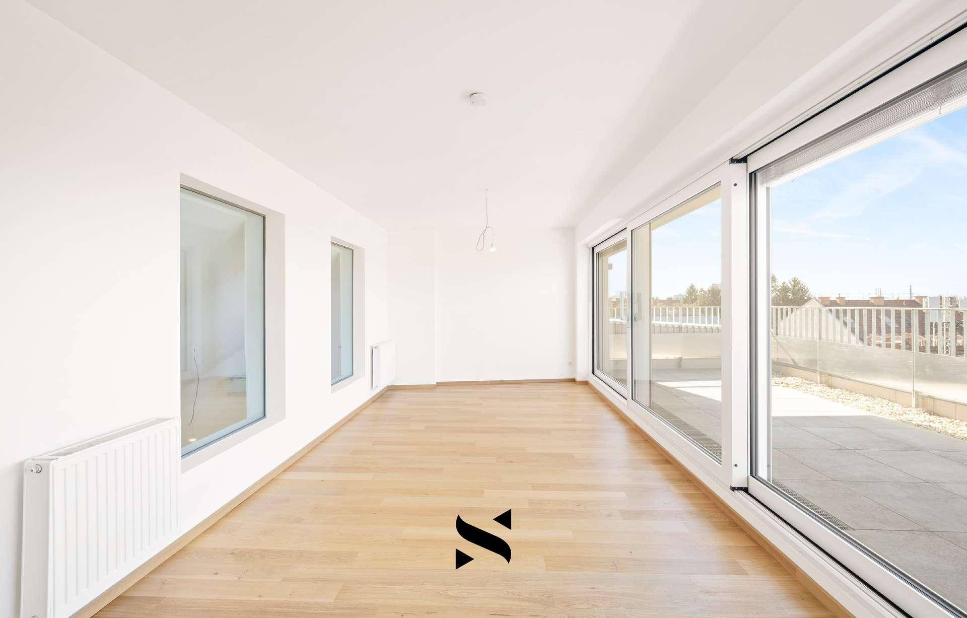 Heller Wohnraum mit Holzparkettboden und großen Schiebetüren zur Dachterrasse.