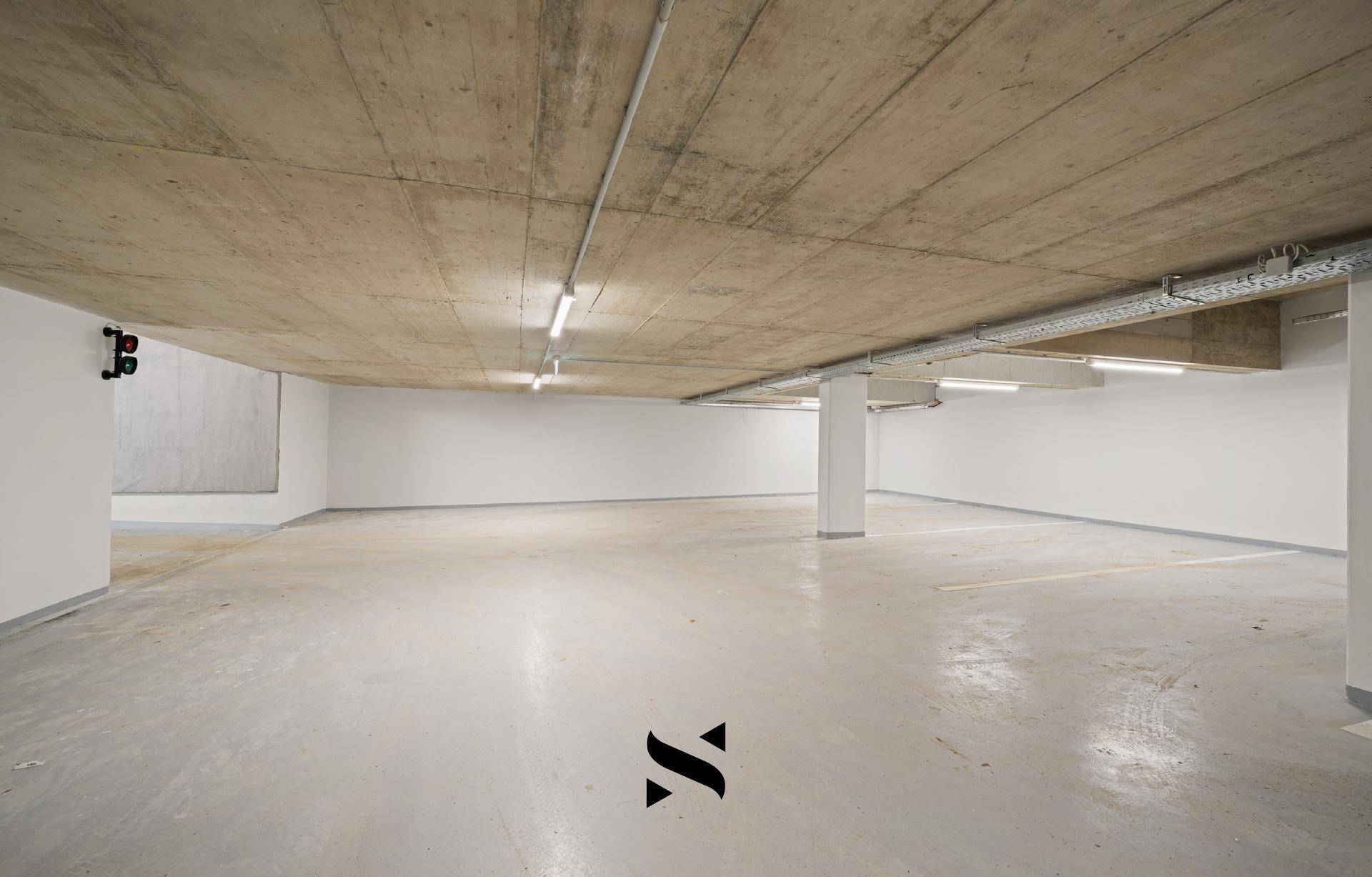 Geräumige Tiefgarage mit Betonboden und ausreichend Platz für mehrere Fahrzeuge.