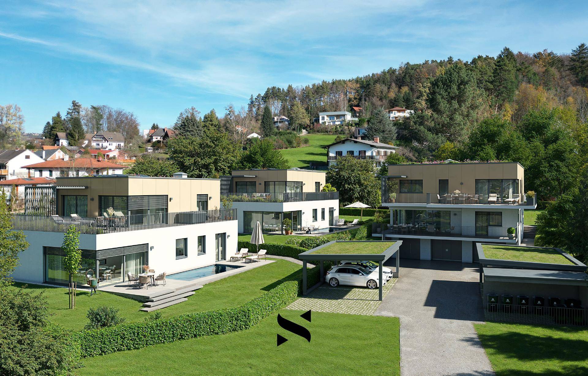 Eine Gruppe moderner Villen mit Flachdächern und Carports, eingebettet in eine grüne Hügellandschaft.