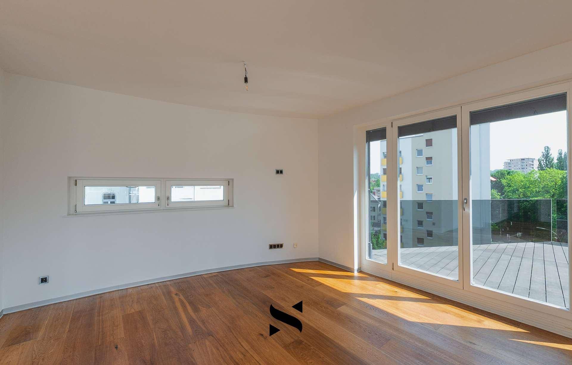 Helles Zimmer mit Holzboden und Zugang zu einer Terrasse mit Stadtblick.