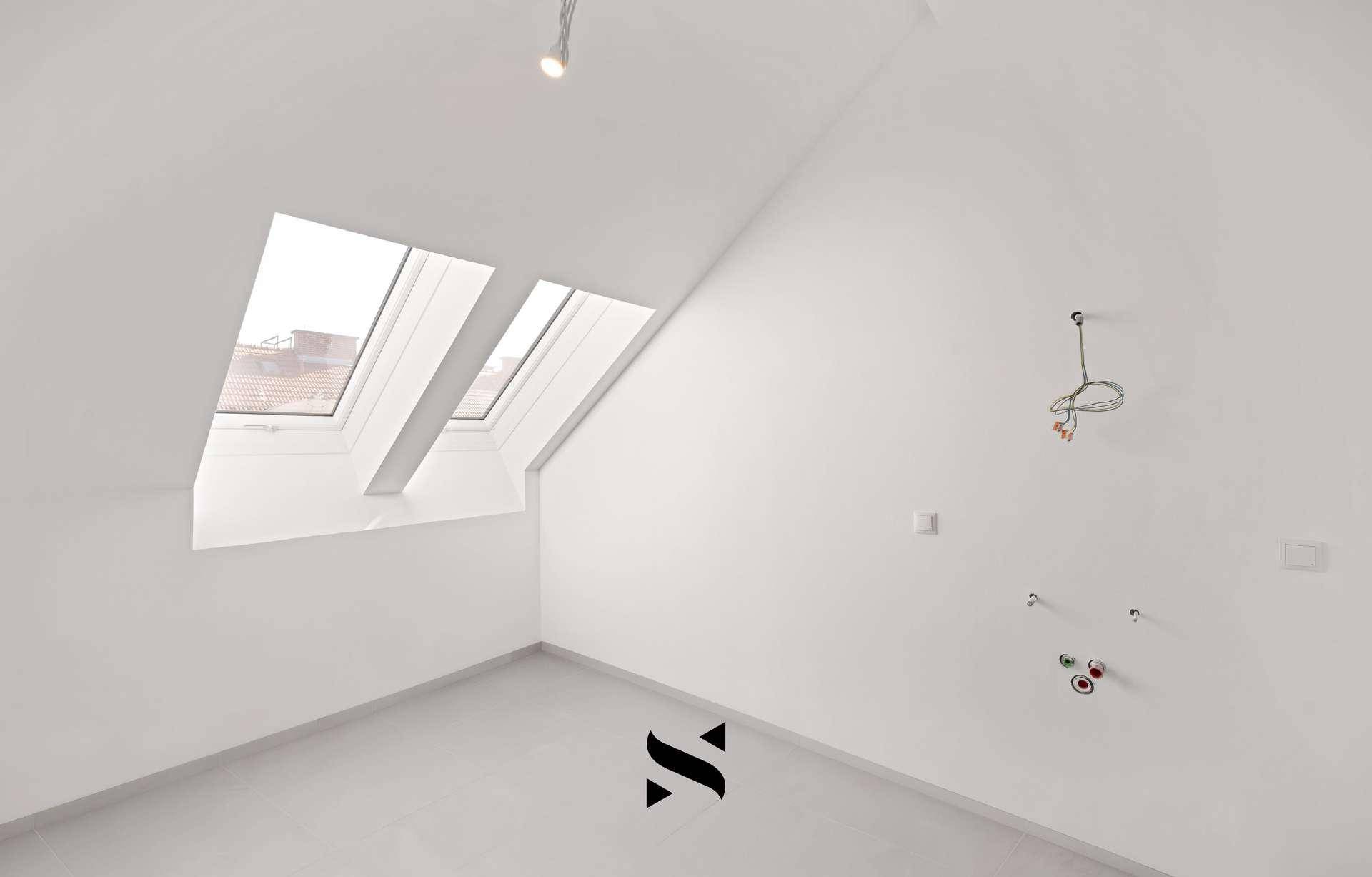 Raum im Dachgeschoss mit Dachfenstern und Anschlüssen für Sanitärinstallationen.