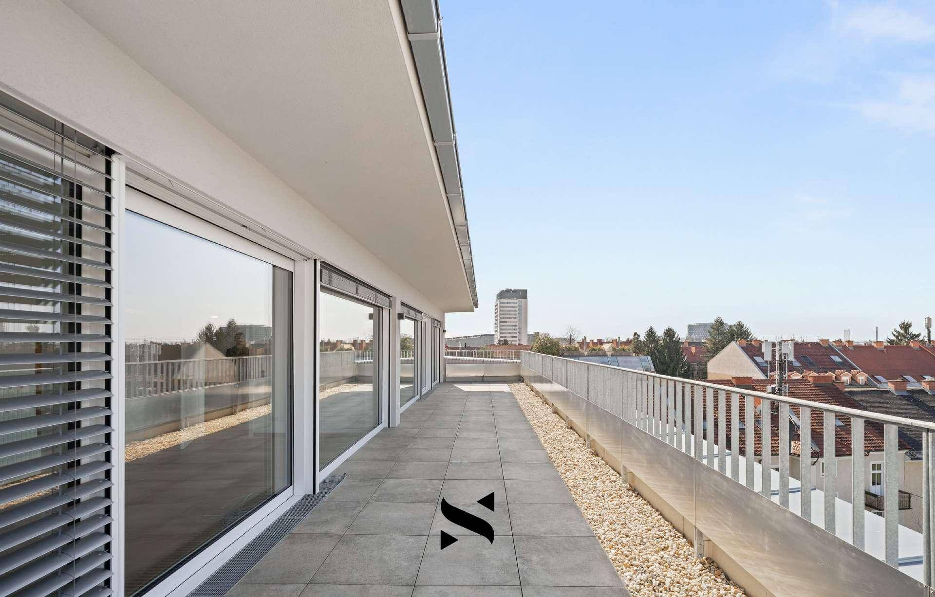 Große Dachterrasse mit Fliesenboden, Metallgeländer und weitem Stadtblick.