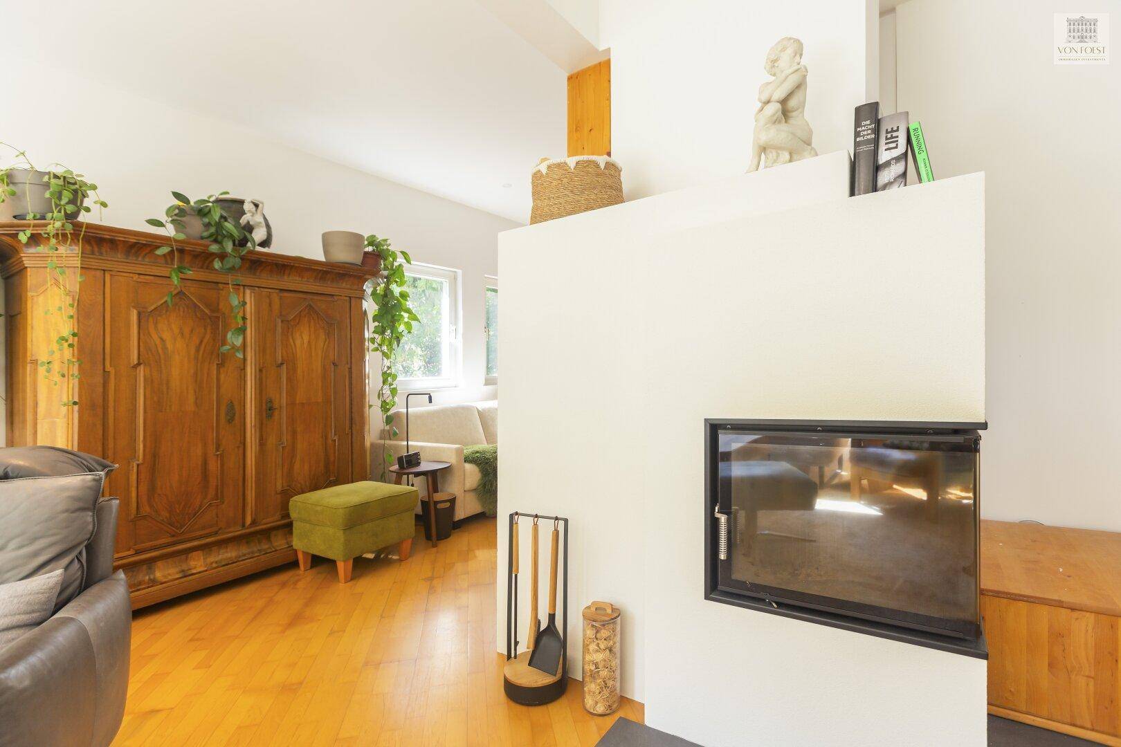 Gemütliches Wohnzimmer mit Holzboden, Kamin und antiken Holzmöbeln.