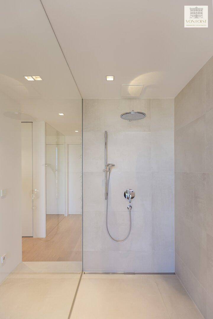 Elegante begehbare Dusche mit Regenduschkopf und minimalistischem Design.