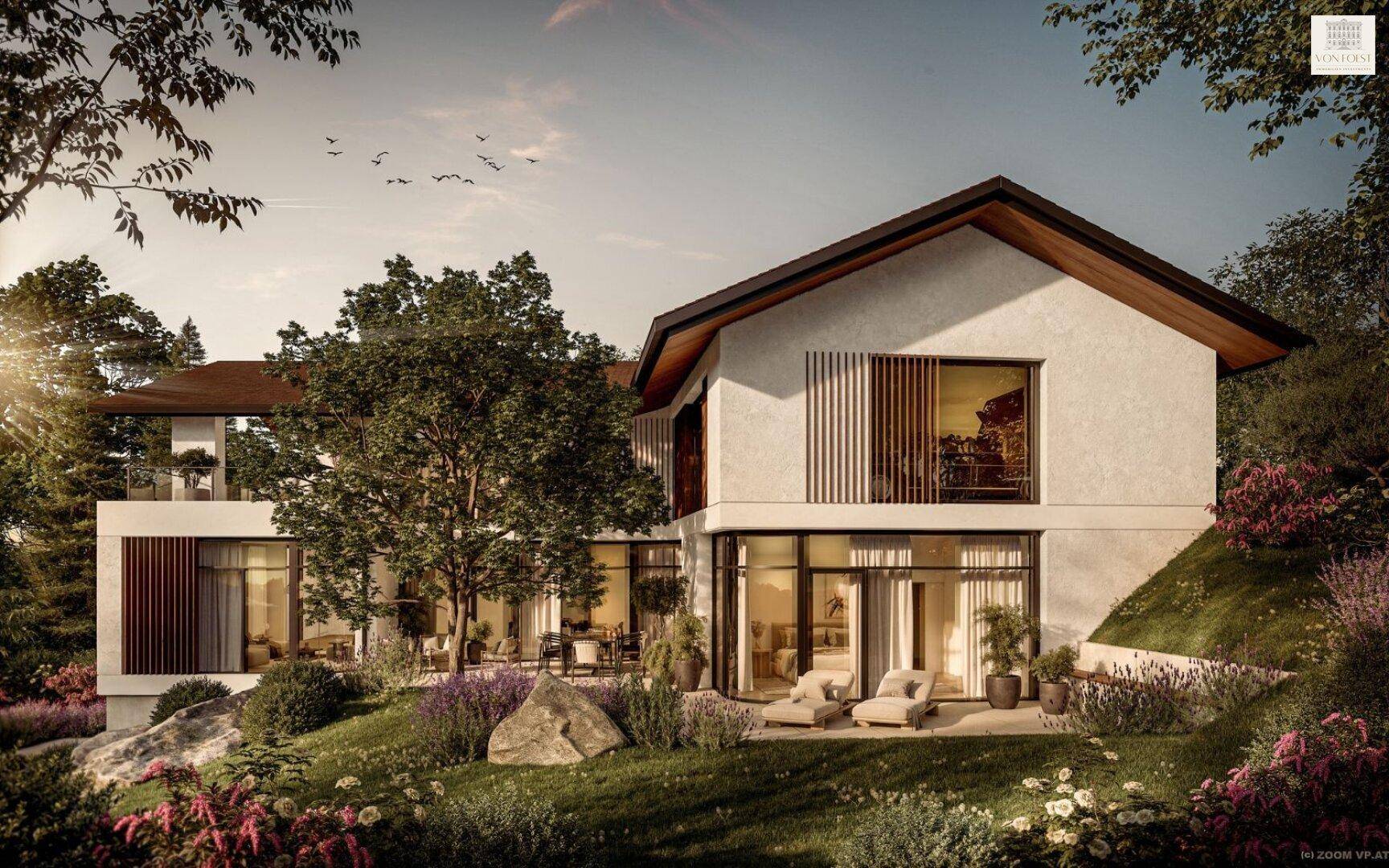 Rückansicht der modernen Villa mit großer Terrasse und Liegestühlen im Grünen.