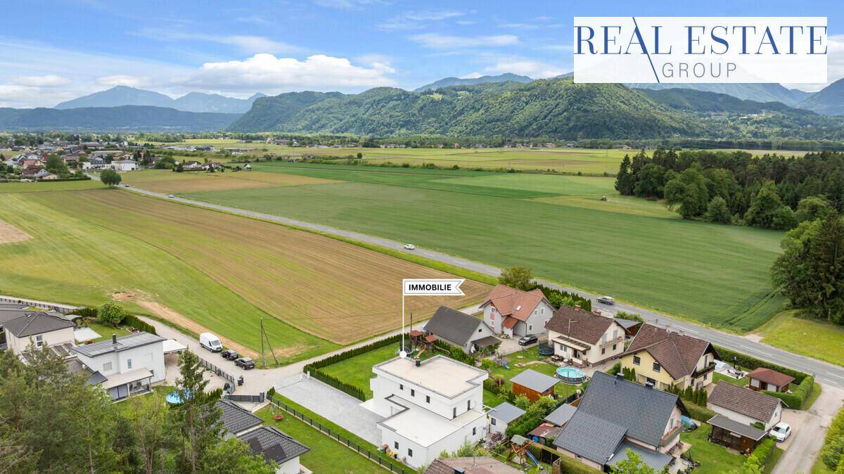Luftaufnahme der Immobilie in ländlicher Umgebung mit Bergblick und Feldern.