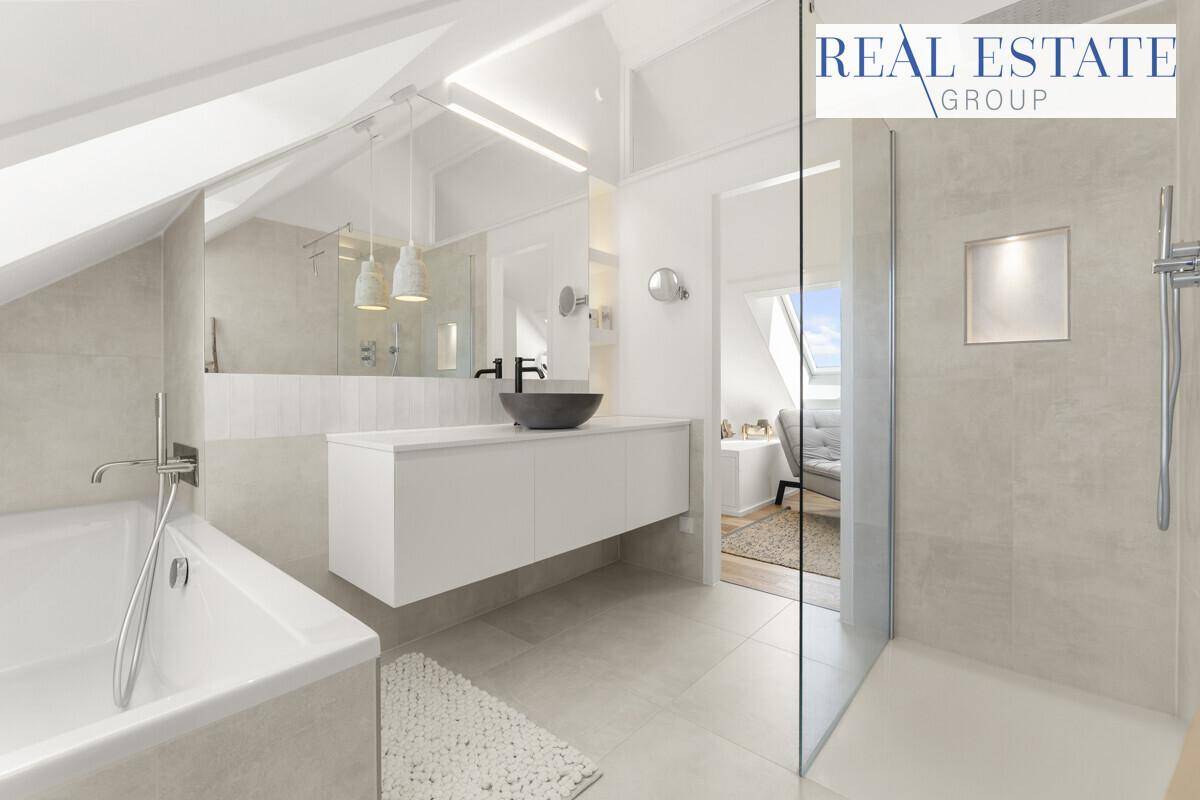 Modernes Badezimmer mit Badewanne, begehbarer Dusche, schwebendem Waschtisch und großen Fliesen.
