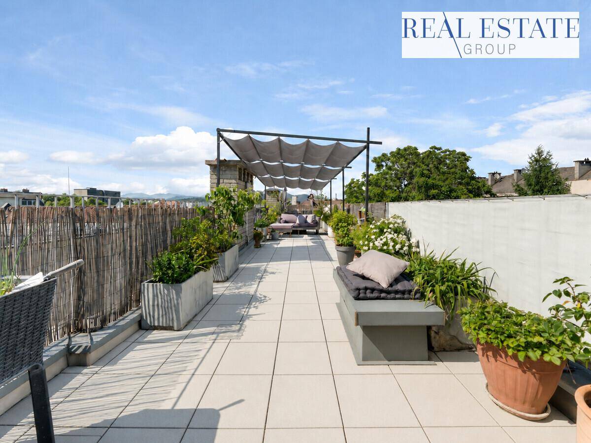 Geräumige Dachterrasse mit Sitzgelegenheiten, Pflanzen und Sonnenschutz, ideal zum Entspannen.