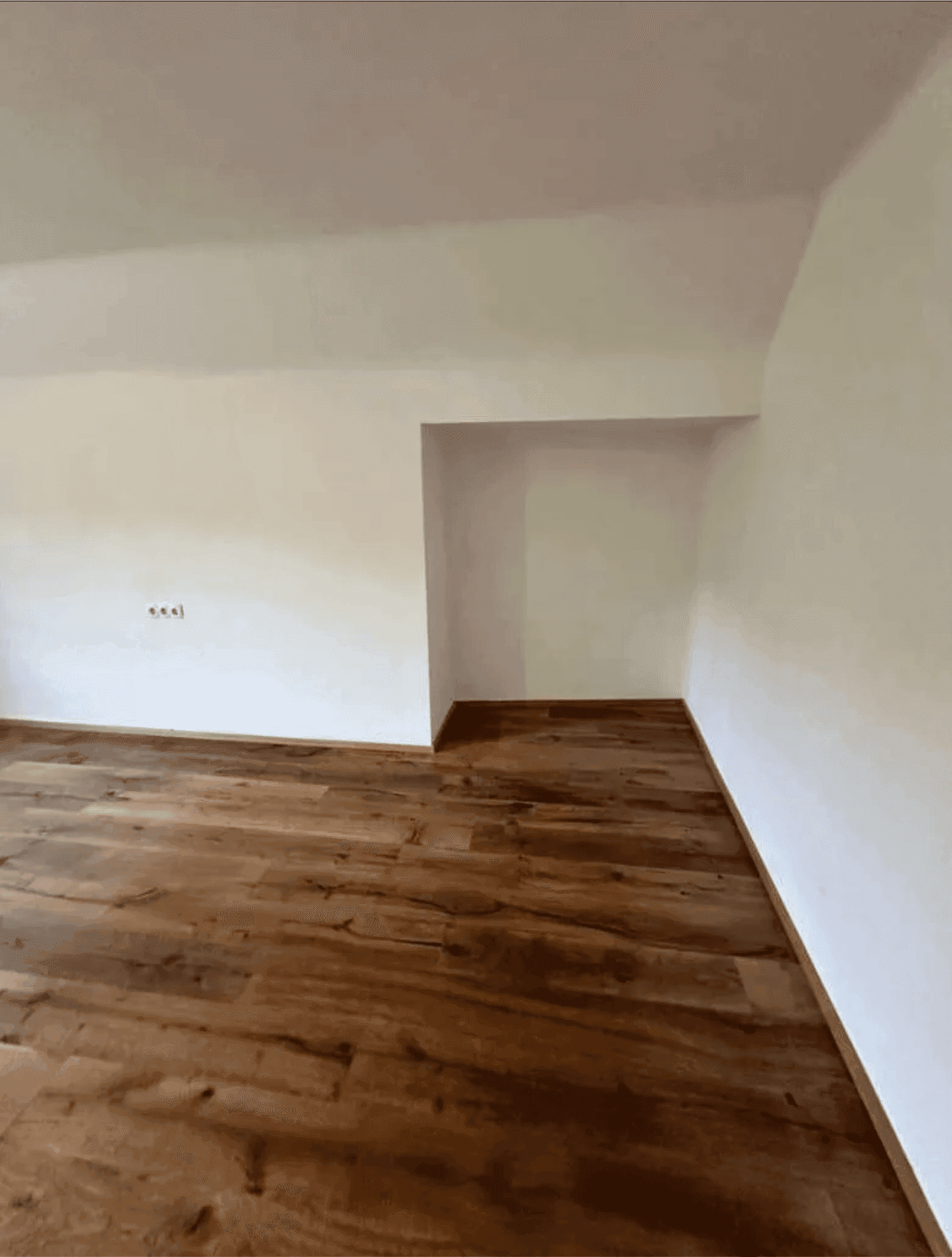 Helles Zimmer mit Holzboden und einer praktischen Nische, die vielseitig genutzt werden kann.
