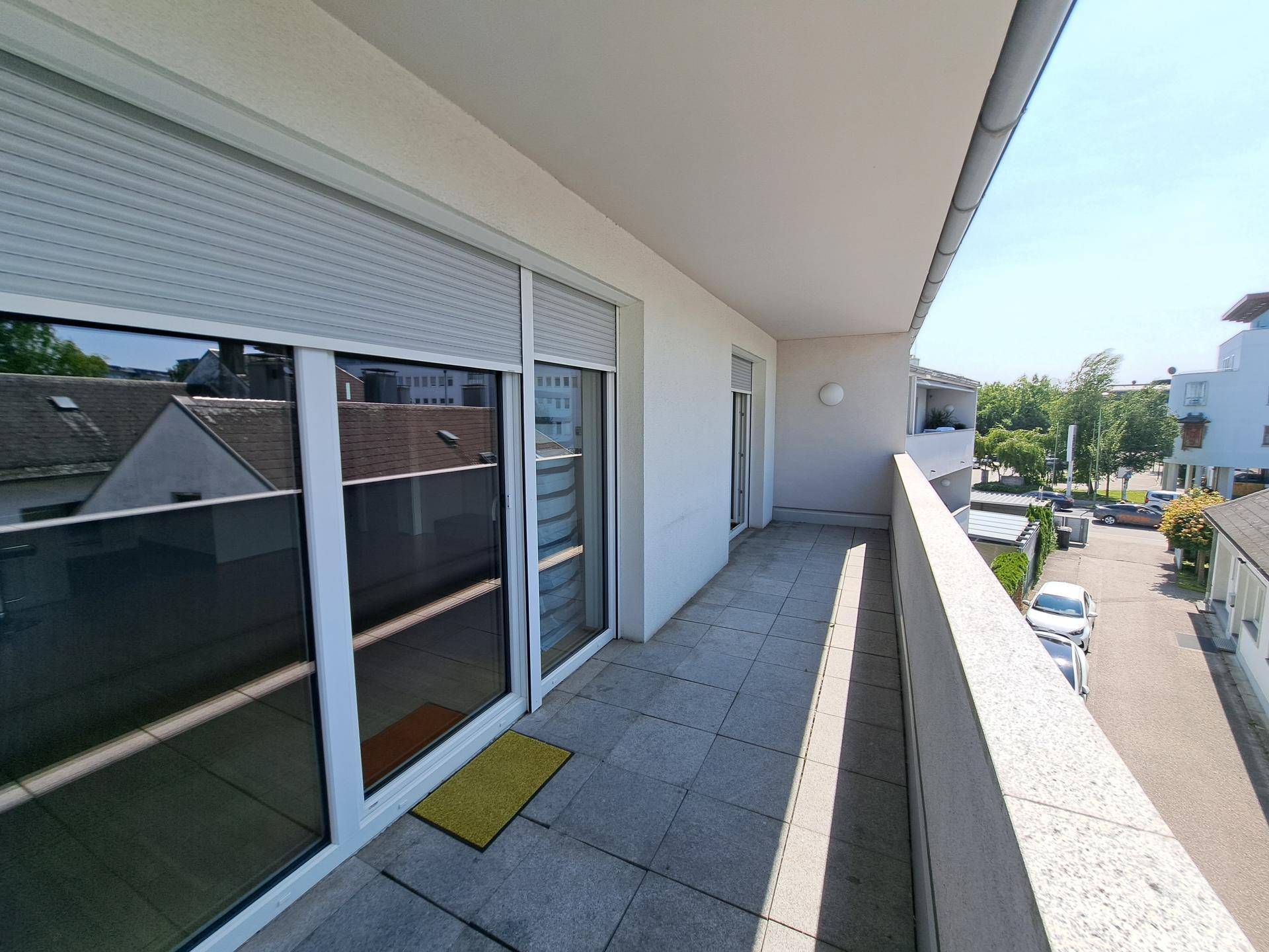 Geräumiger Balkon mit Fliesenboden und Blick auf die umliegende Wohngegend.