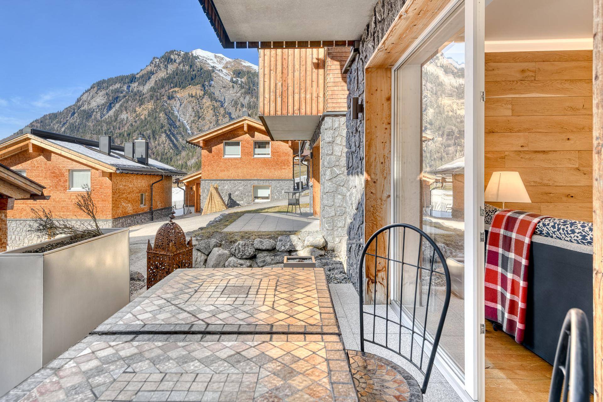 Gemütlicher Balkon mit Steinfliesen und Tisch, bietet einen schönen Blick auf die Berge.