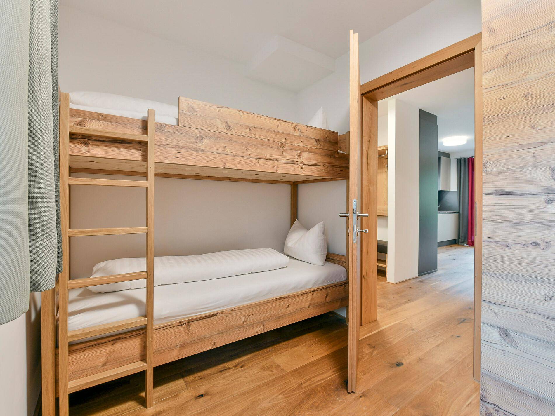 Kinderzimmer mit Etagenbett aus Holz und Holzboden, ideal für Gäste.