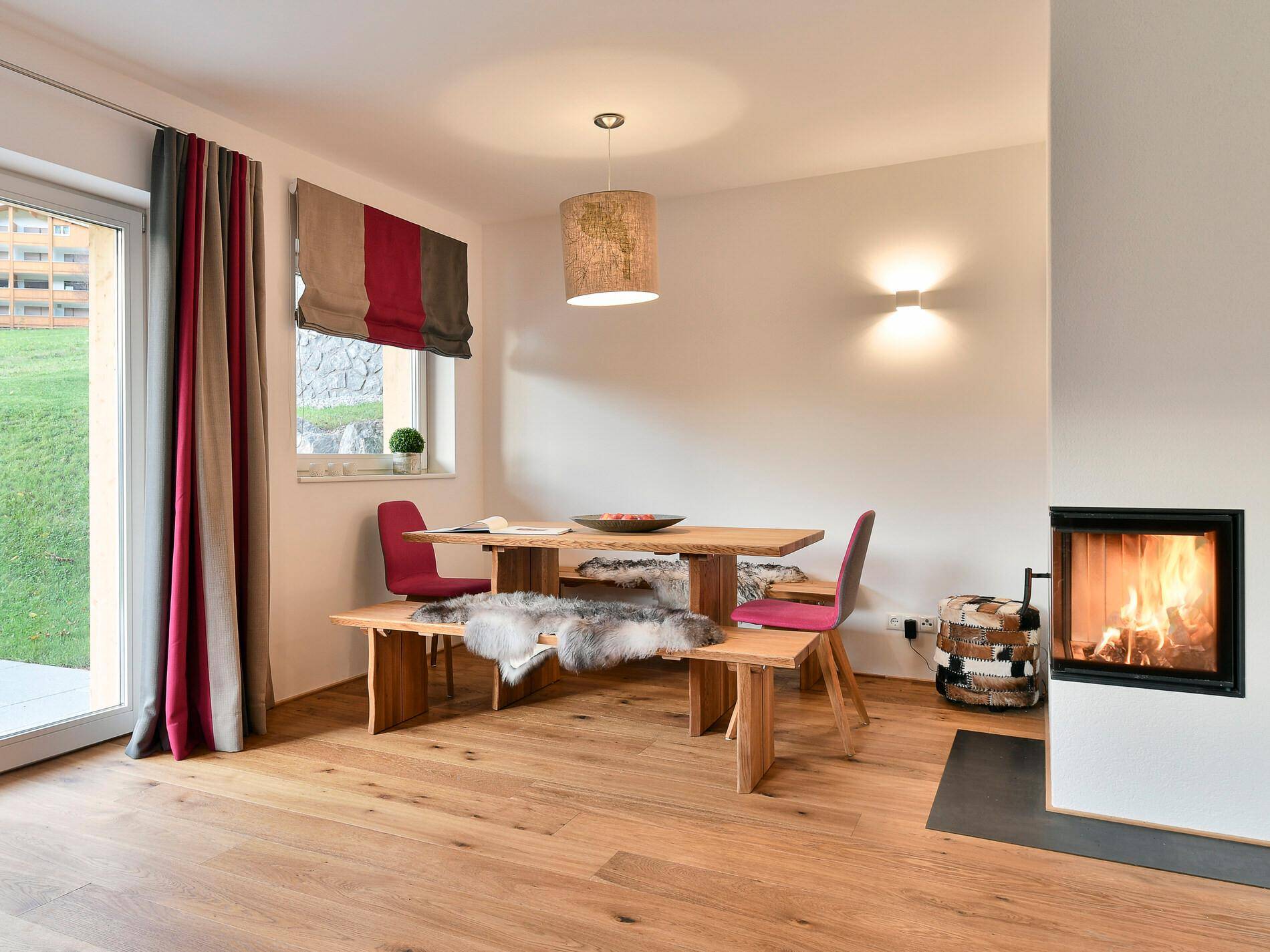 Gemütlicher Wohn-Essbereich mit Holzboden, Kamin und Zugang zur Terrasse.