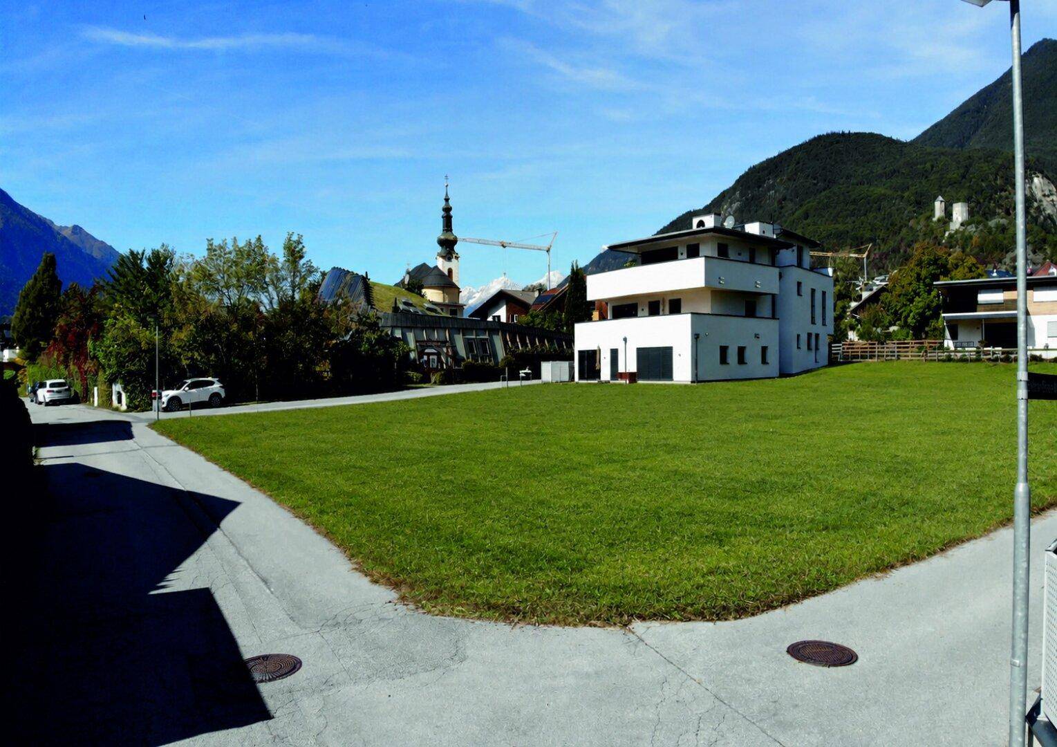 Neubau in ruhiger Lage mit großer Grünfläche und Blick auf die umliegenden Berge.