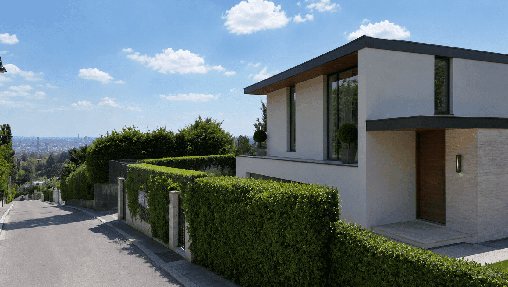 Elegante moderne Villa von der Straße aus gesehen, umgeben von einer hohen Hecke.