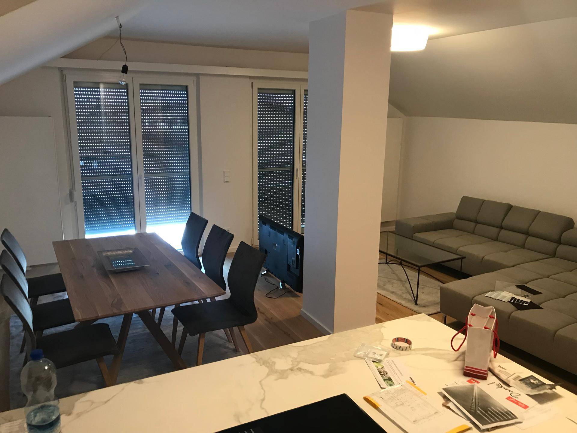 Geräumiger Wohn-Essbereich mit offener Küche, Holztisch und gemütlicher Sofalandschaft.
