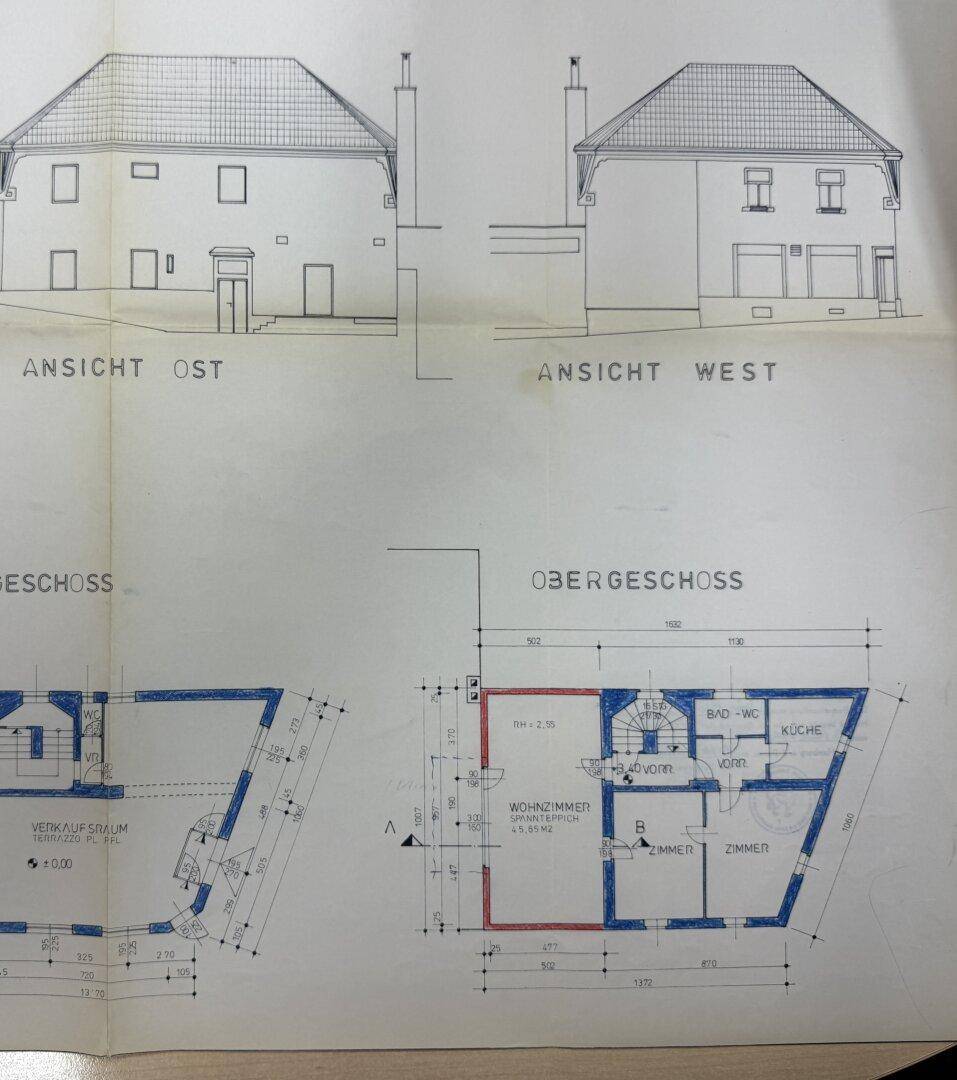 Ansichten des Gebäudes und Grundriss des Obergeschosses mit Wohnzimmer, Bad und Küche.
