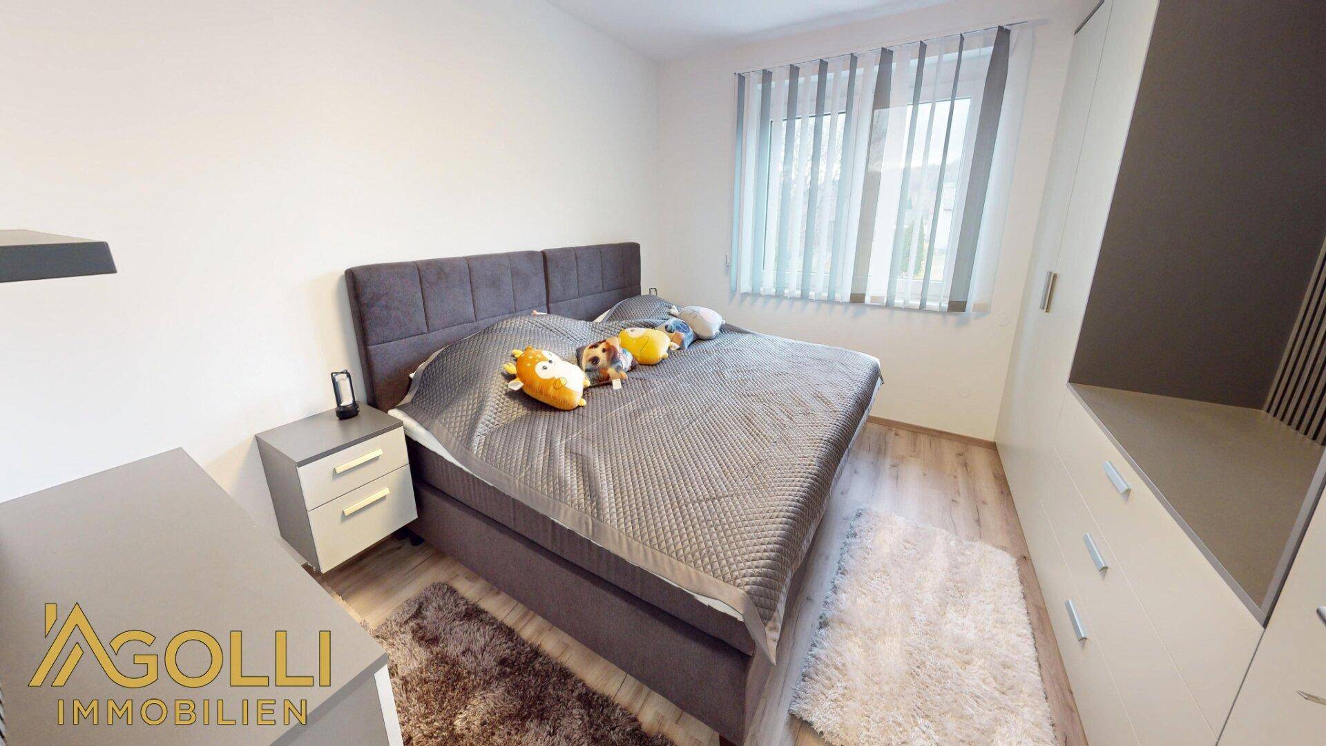 Helles Schlafzimmer mit Doppelbett, Nachttischen und großem Fenster.