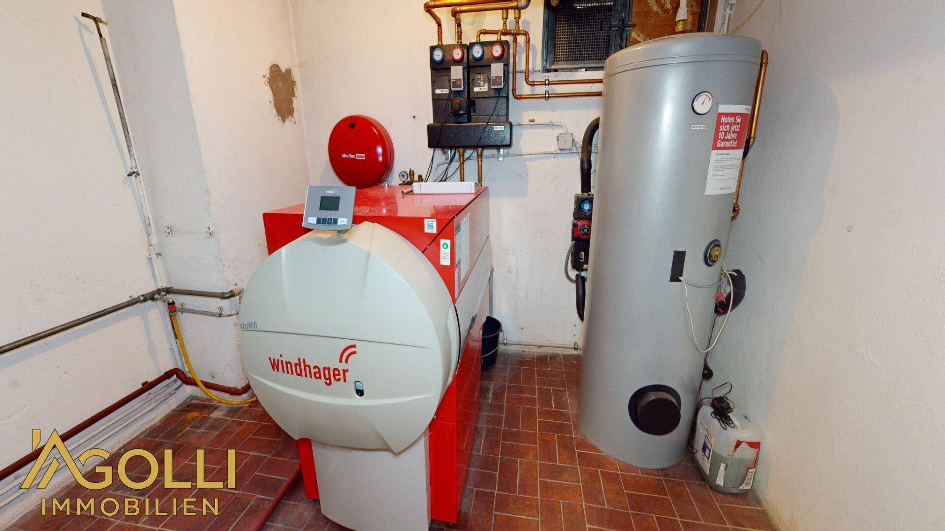 Heizungsraum mit moderner Pelletheizung und Warmwasserspeicher, gut gewartet und funktional.