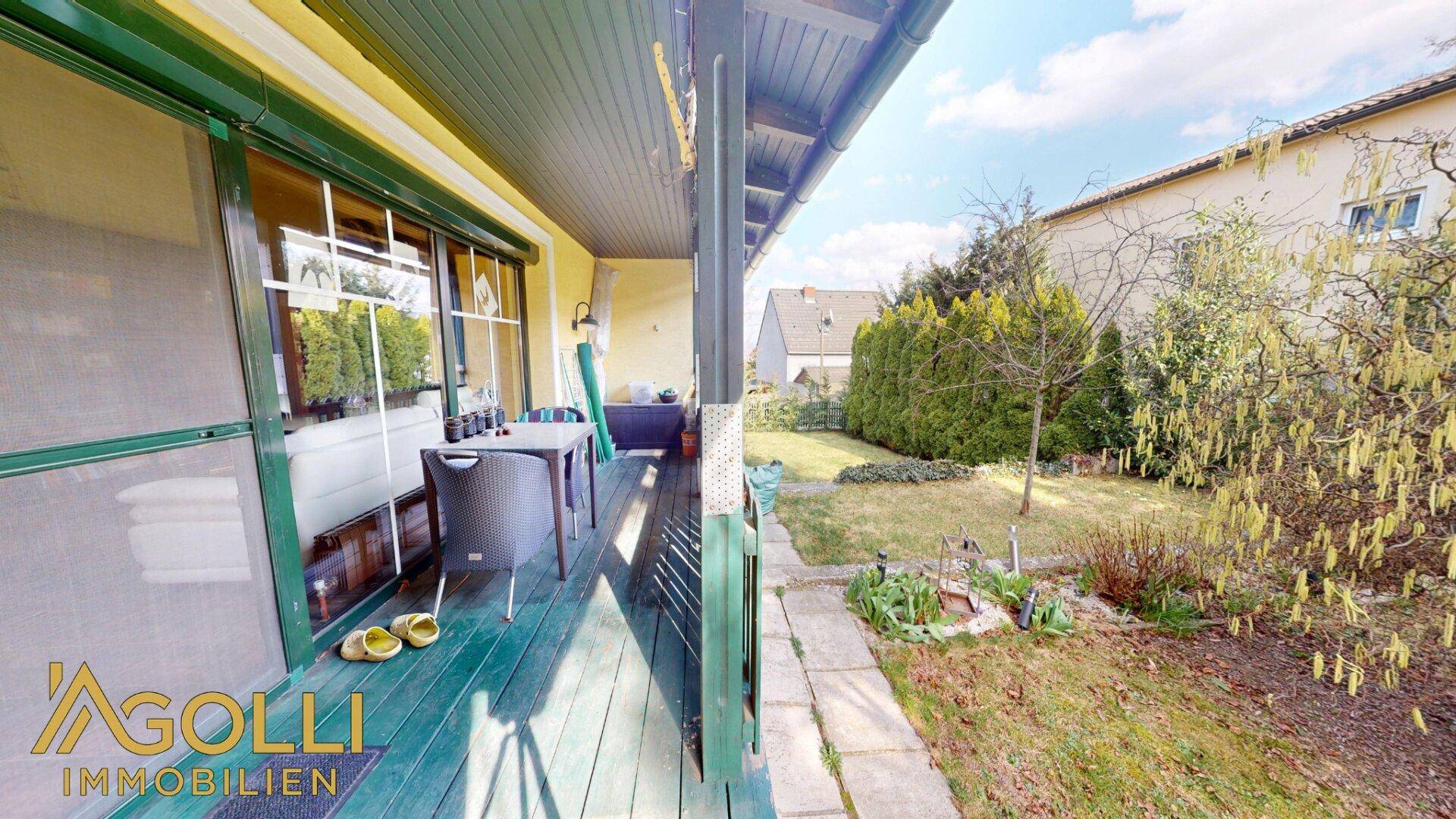 Überdachte Terrasse mit Sitzgelegenheiten und Blick in den gepflegten Garten, ideal zum Entspannen.