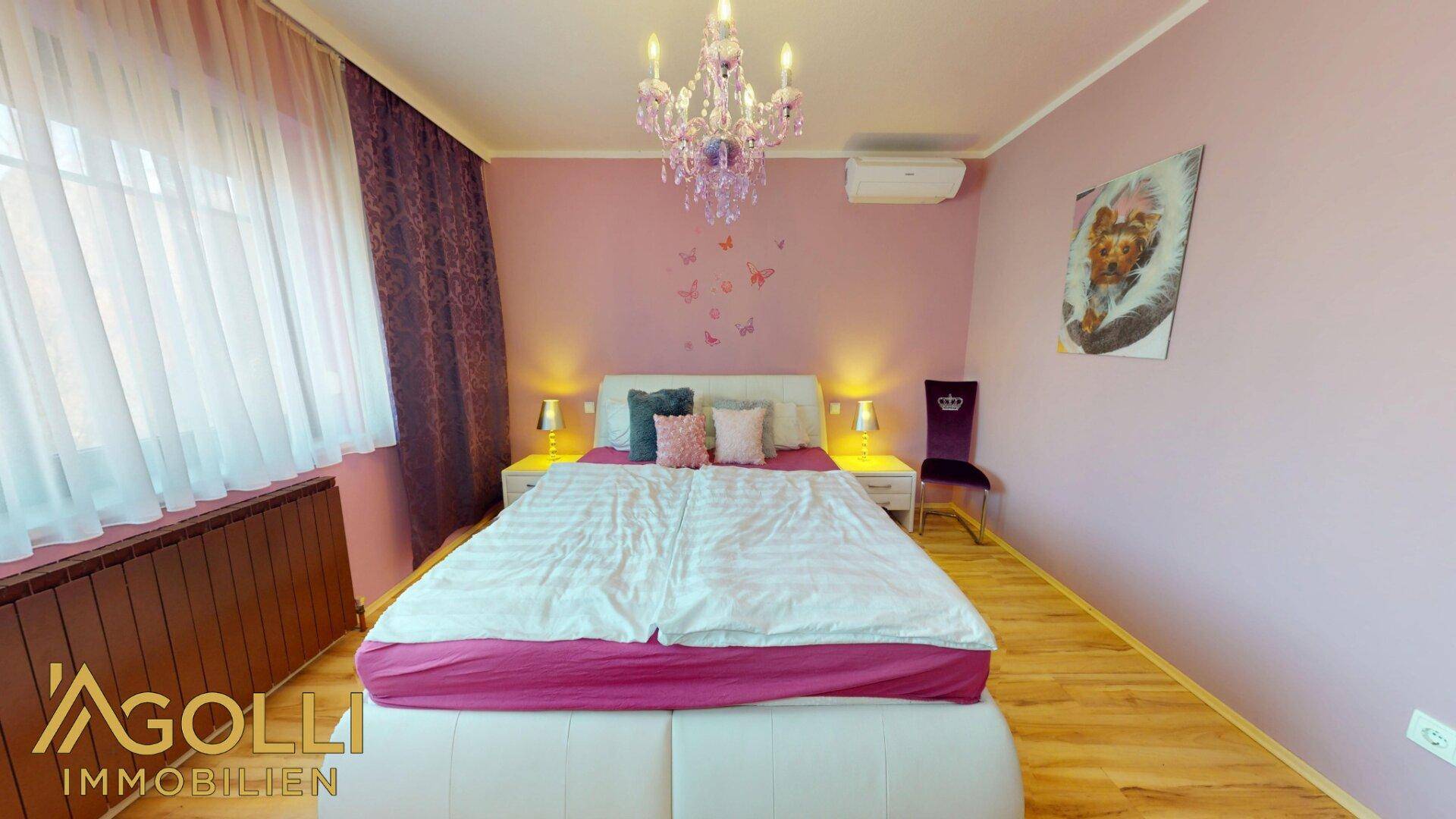 Helles Schlafzimmer mit rosa Wänden, großem Bett und Fenster mit Vorhängen, das viel Tageslicht bietet.