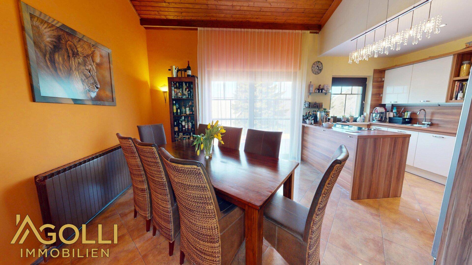 Gemütlicher Essbereich mit großem Holztisch, passenden Stühlen und Fliesenboden, ideal für Familienessen.
