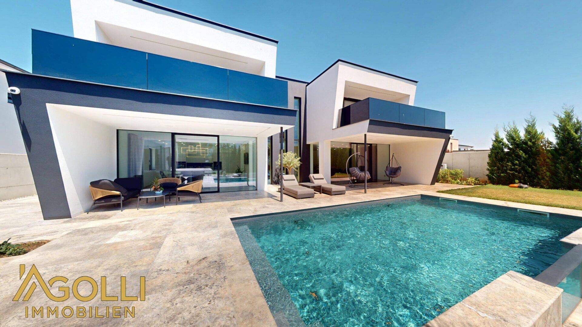 Elegante Poolterrasse mit bequemen Liegen und direktem Zugang zum Haus.