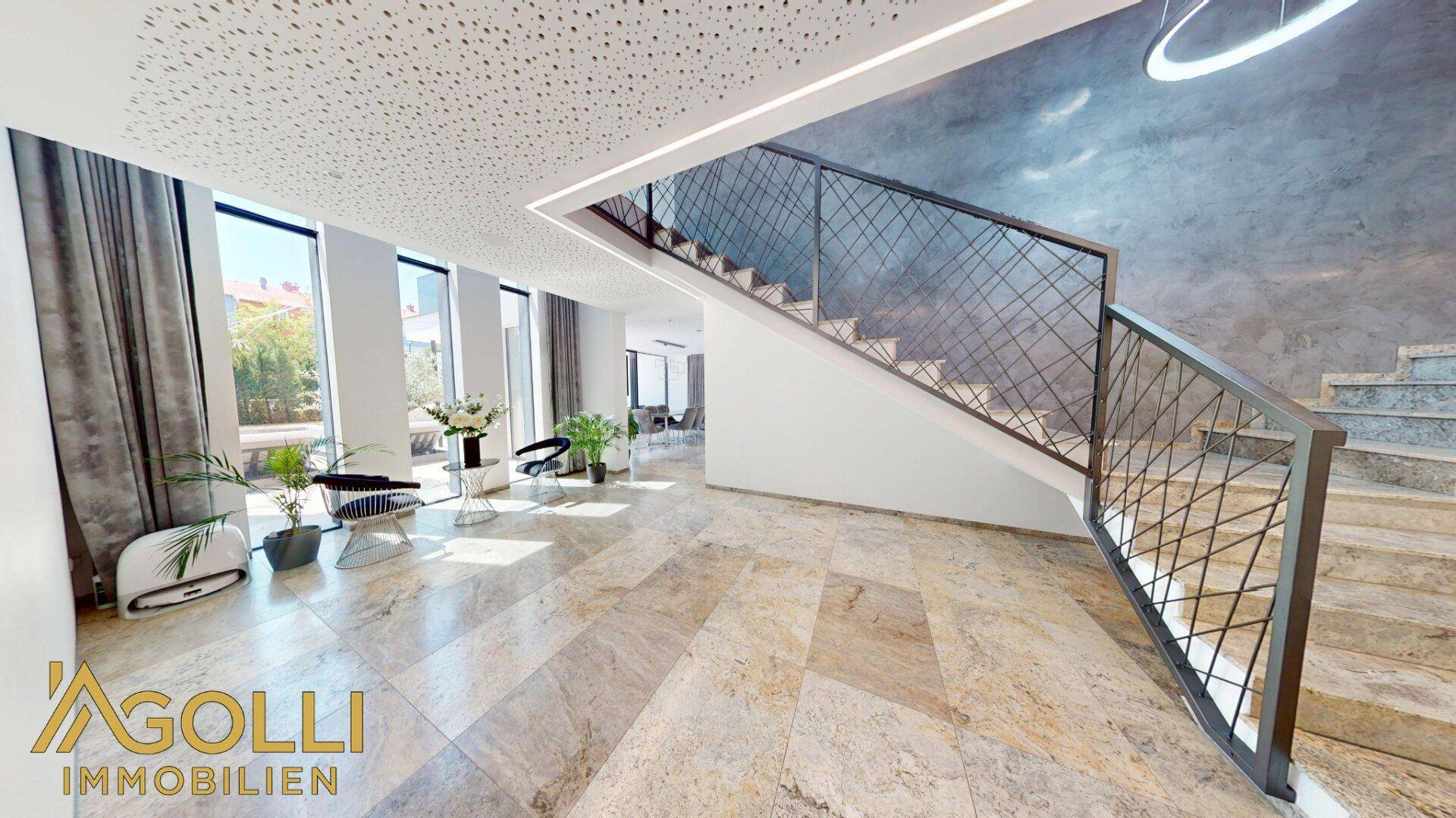Moderner Eingangsbereich mit eleganter Treppe und hochwertigem Steinboden.