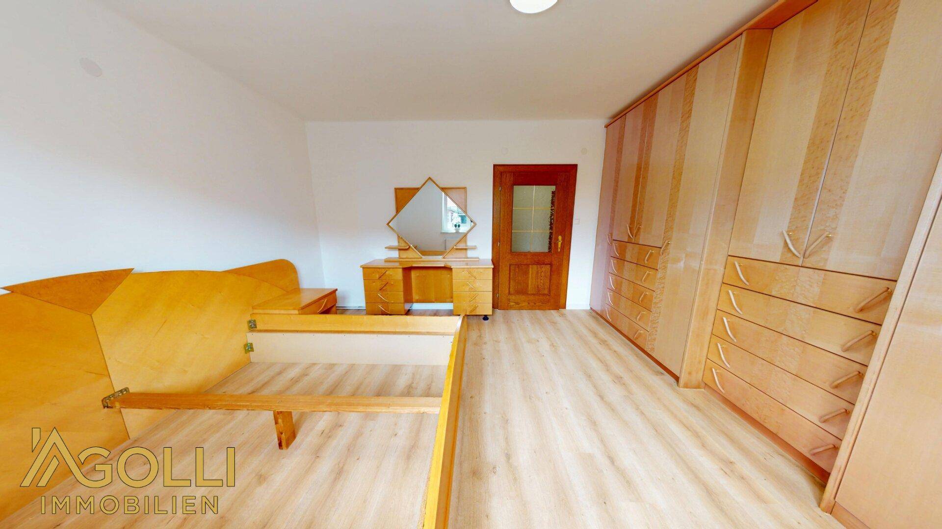 Schlafzimmer mit Einbauschränken aus Holz und einem passenden Schminktisch.