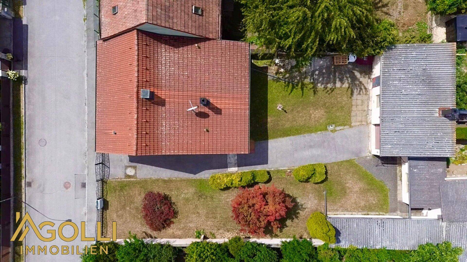 Draufsicht des Grundstücks mit Haus, Garten und Zufahrt.