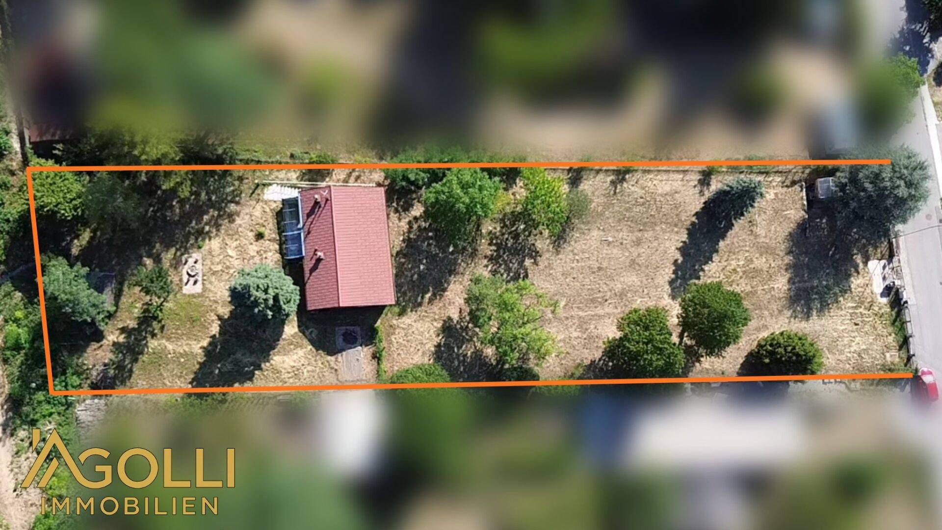 Draufsicht auf das Grundstück mit Haus und Garten, umrandet von einer Markierung.