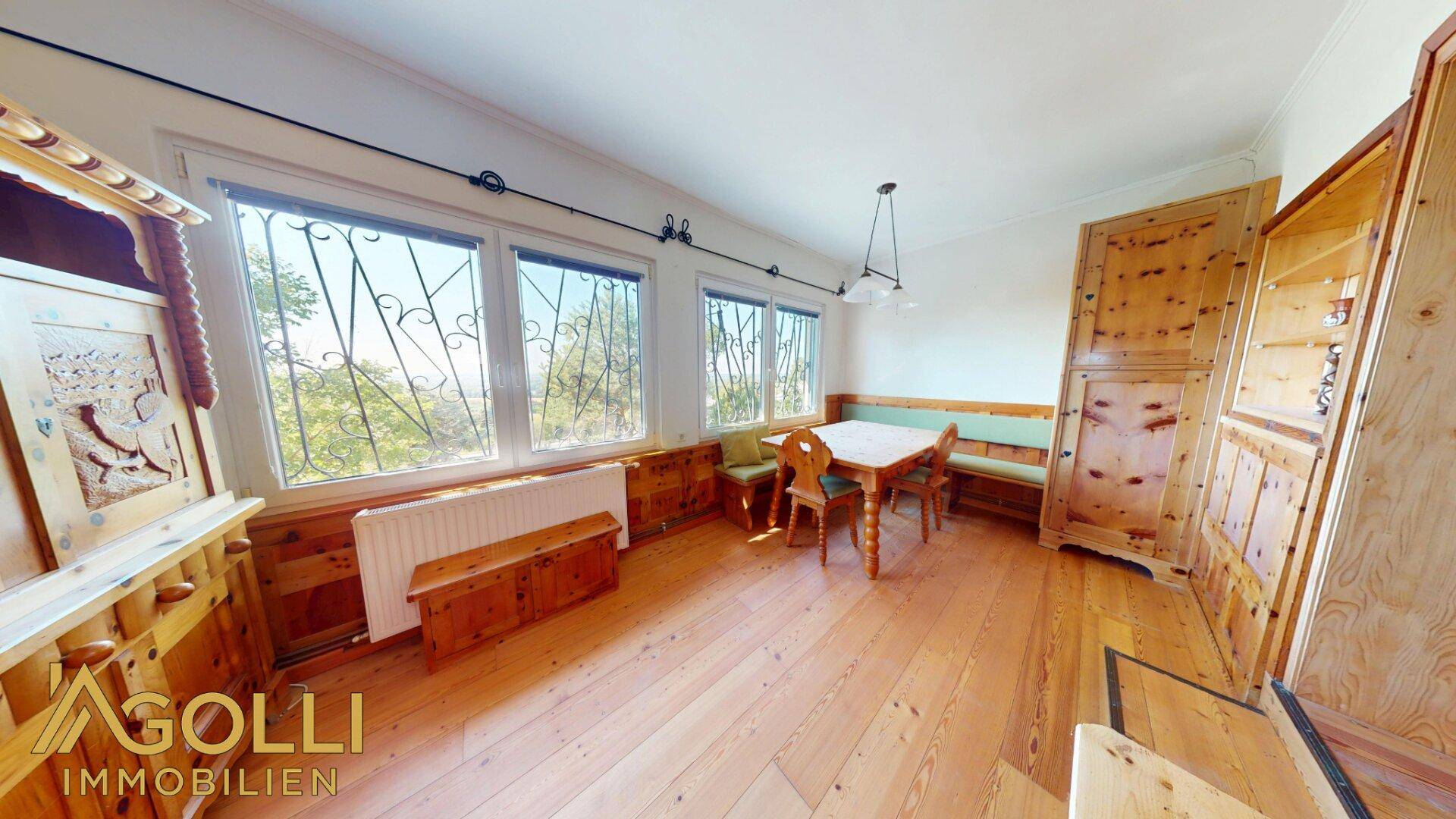 Rustikaler Essbereich mit Holztisch, Bänken und Blick in die Natur.