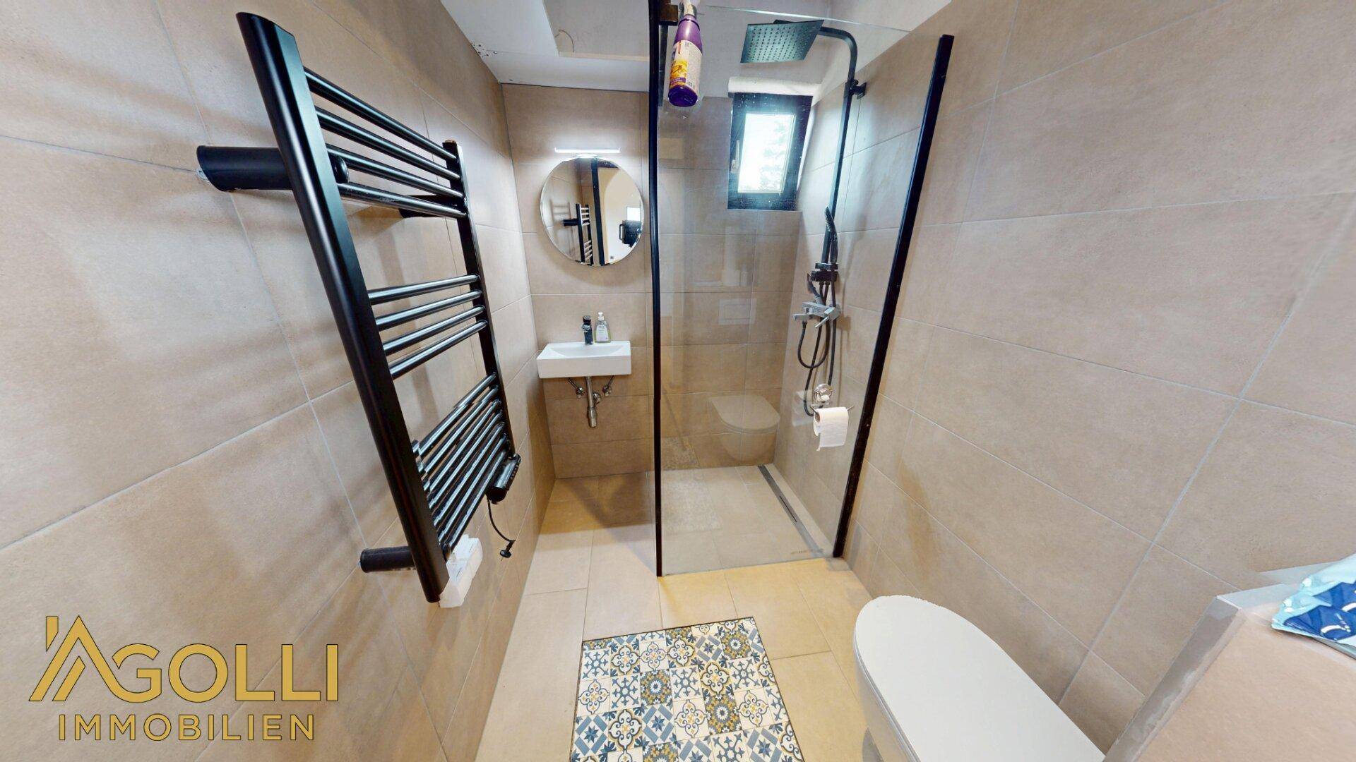 Modernes Badezimmer mit begehbarer Dusche, beheiztem Handtuchhalter und beigefarbenen Fliesen.