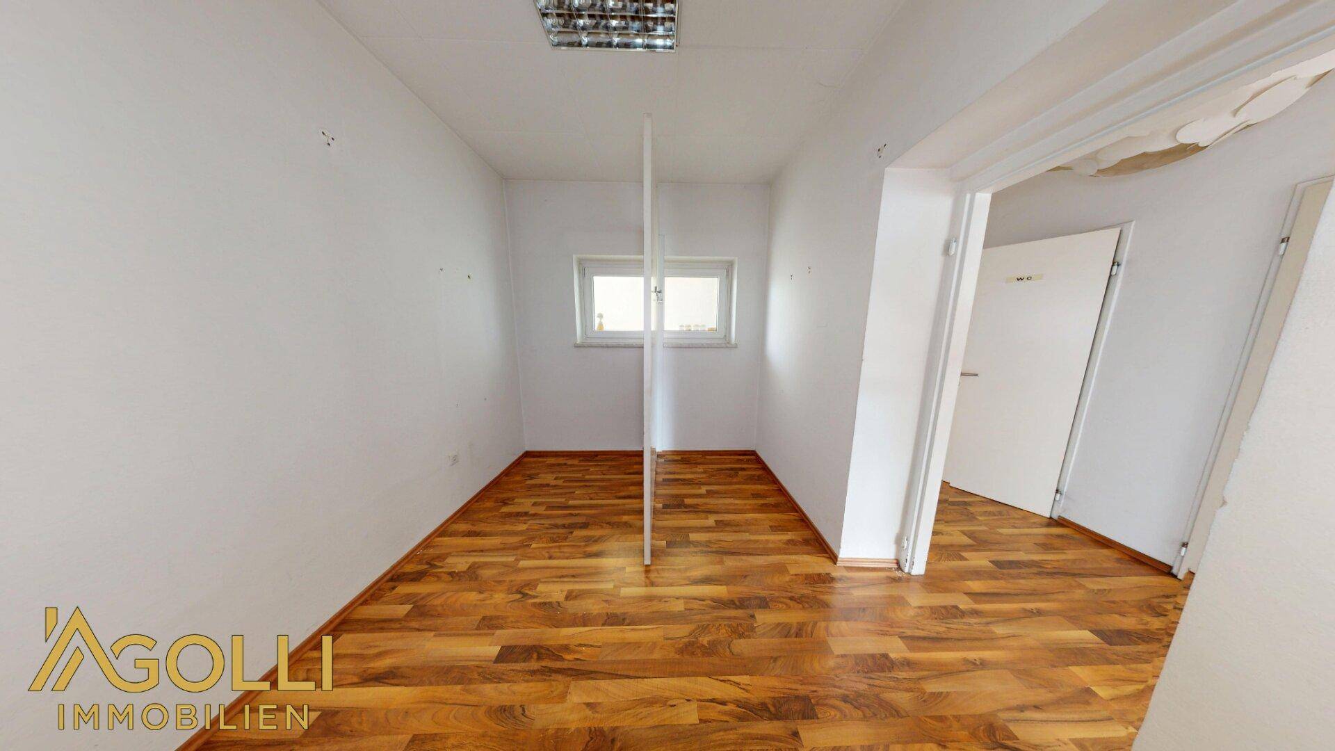 Kleiner Raum mit Fenster und beschädigter Decke, möglicherweise als Lager oder Büro nutzbar.