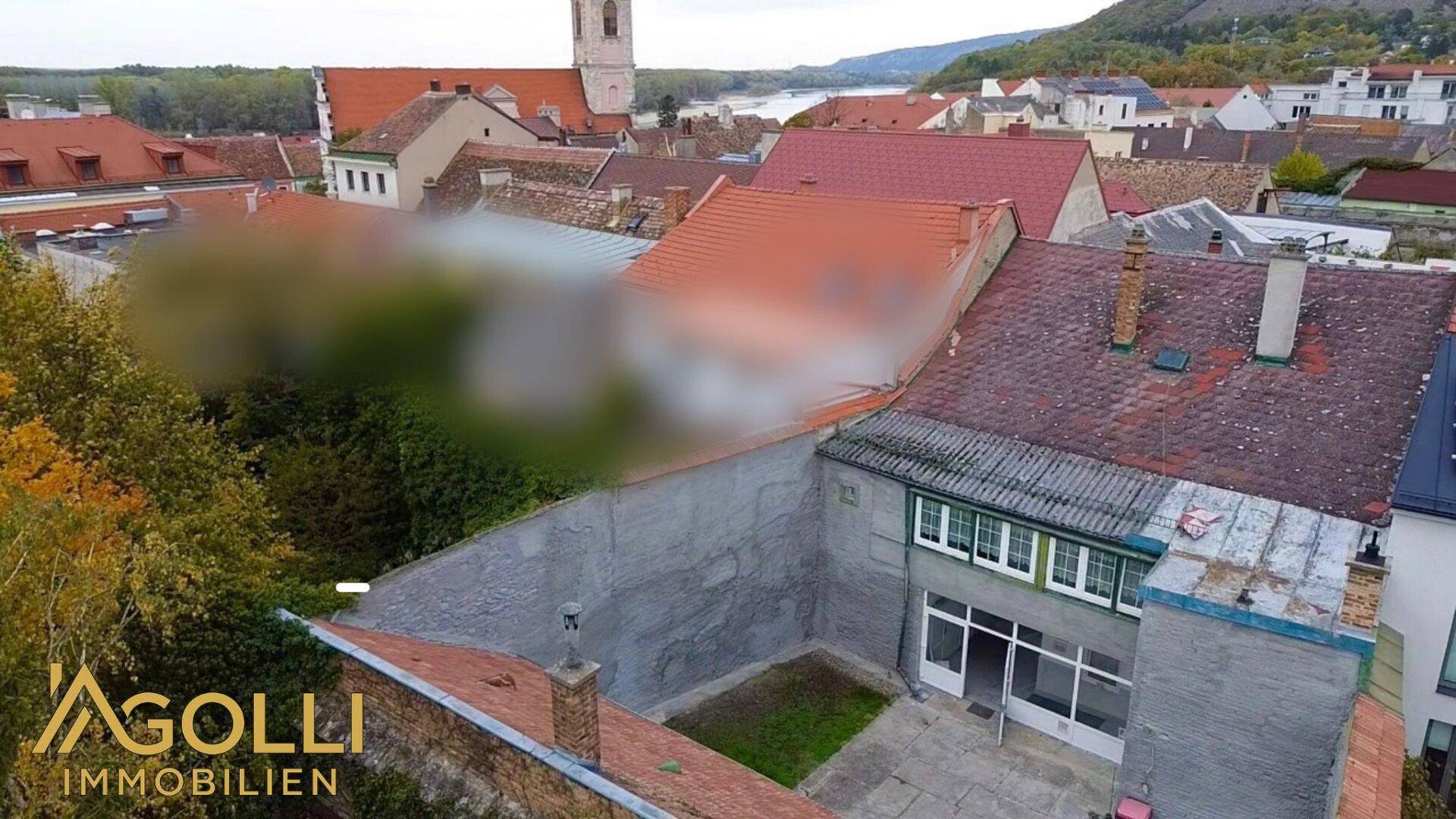 Luftaufnahme des Anwesens mit umliegenden Gebäuden und Blick auf die Stadt und den Fluss.