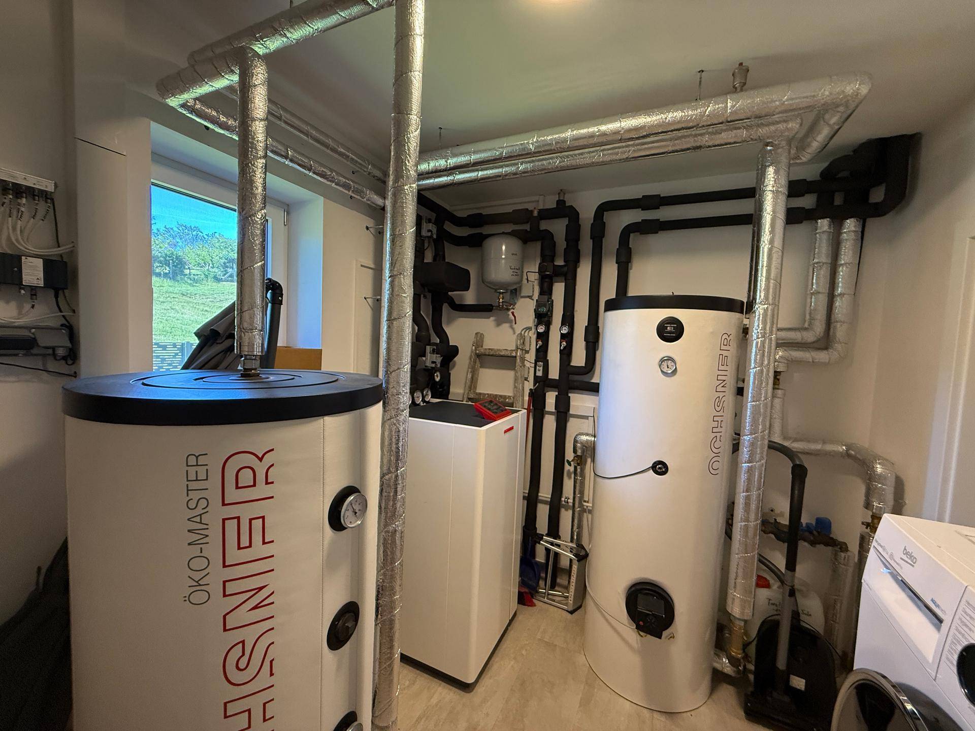 Technikraum mit modernen Heizungsanlagen und Warmwasserspeichern für effiziente Energieversorgung.