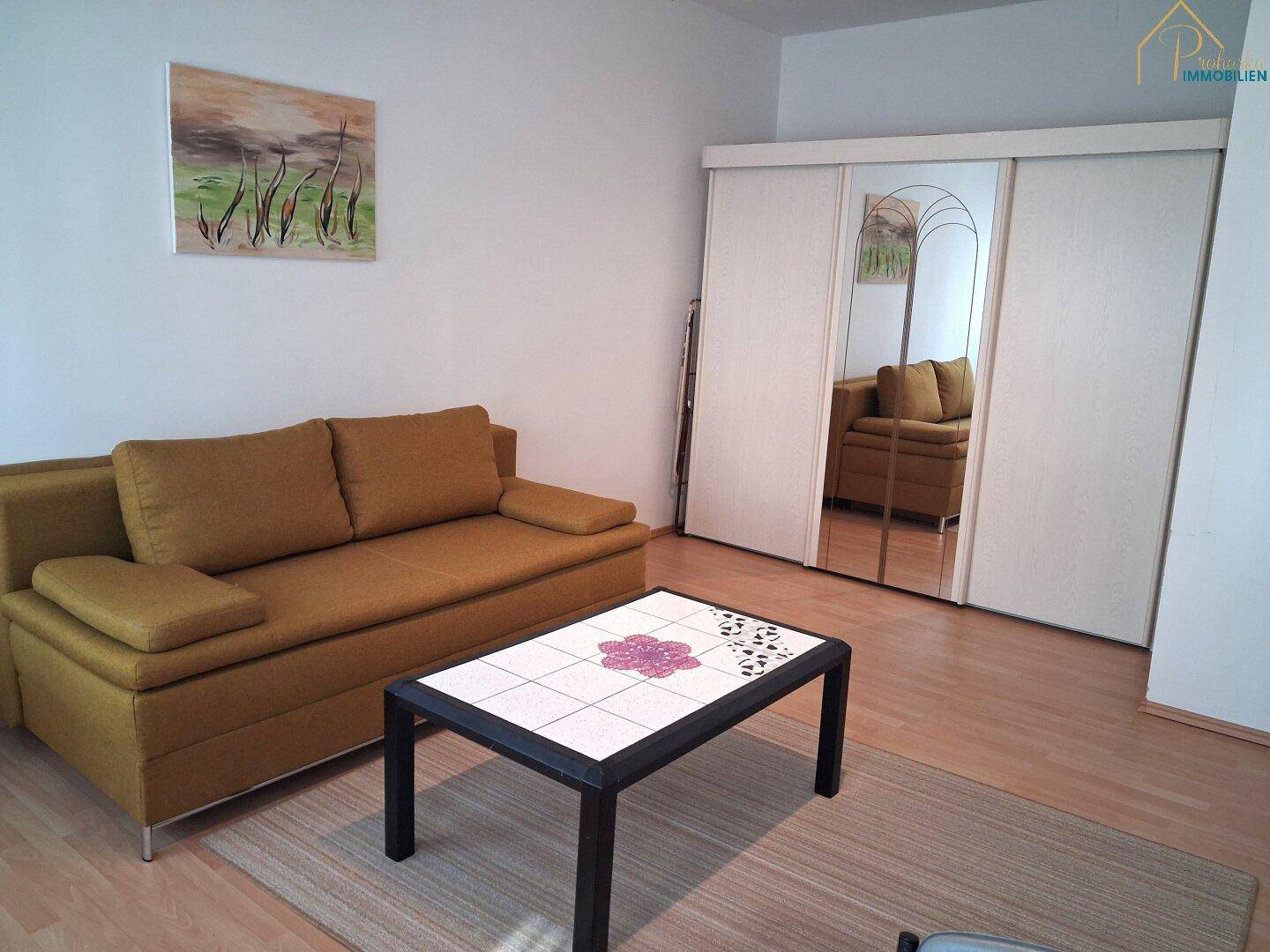 Zimmer mit Schlafsofa und großem Spiegelschrank, ideal als Gäste- oder Arbeitszimmer.