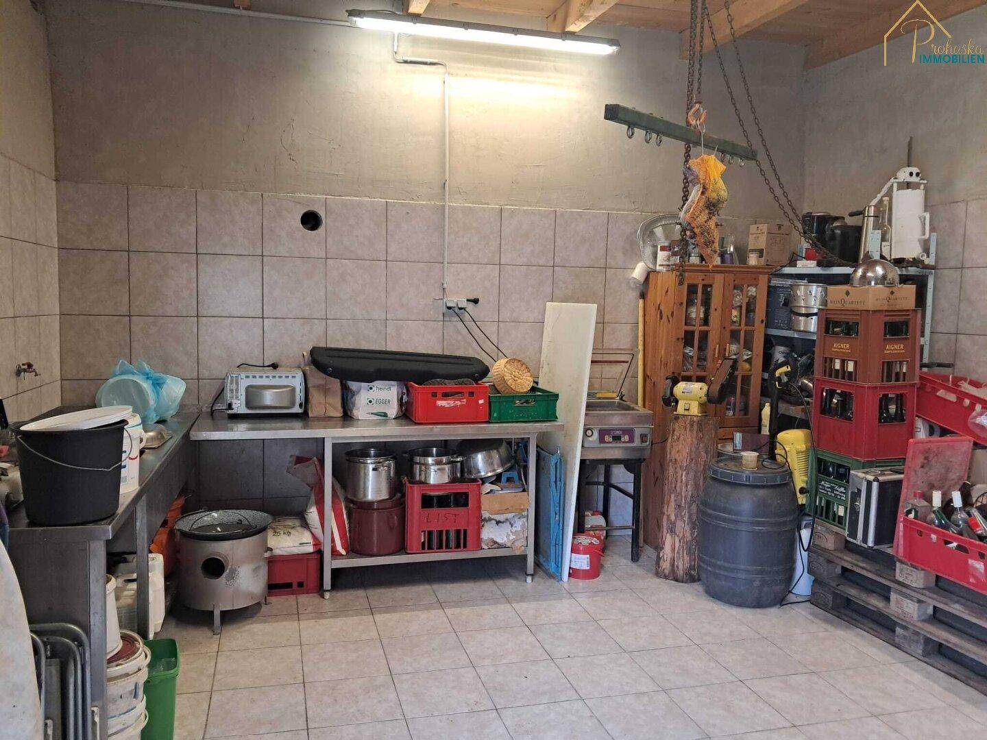 Großer Wirtschaftsraum mit Fliesenboden, Regalen und verschiedenen Vorräten.