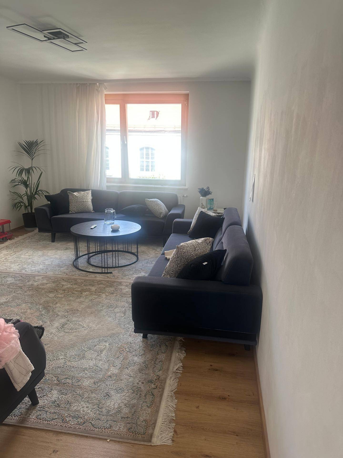 Gemütliches Wohnzimmer mit zwei Sofas, Couchtisch, Teppich und Holzboden.