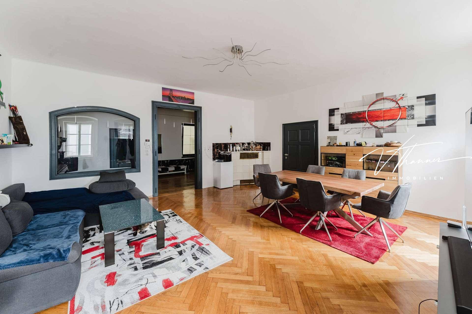 Moderner Wohn-Essbereich mit Holzboden, bequemer Couch und stilvoller Dekoration.