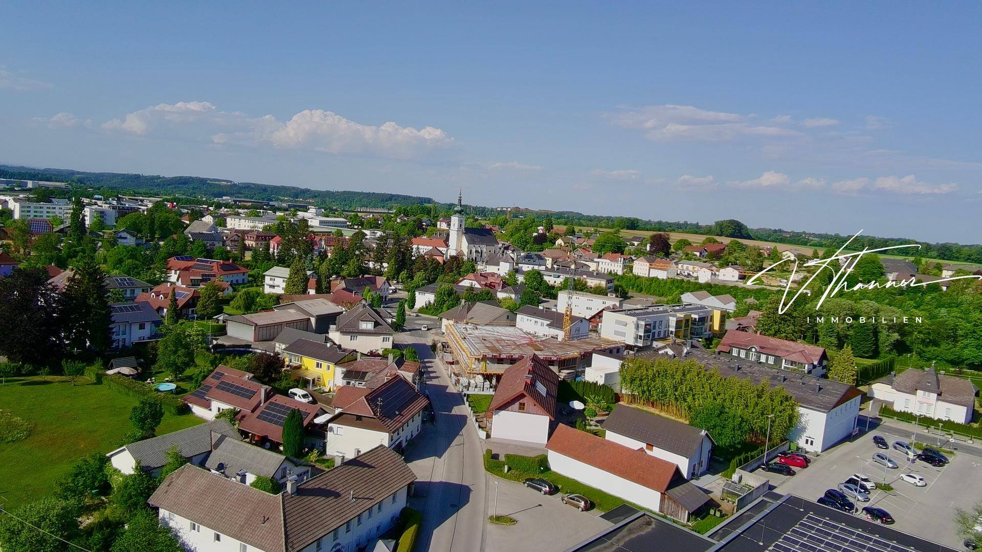 Panoramablick aus der Vogelperspektive auf eine charmante Stadt mit vielen Häusern und einer Kirche.