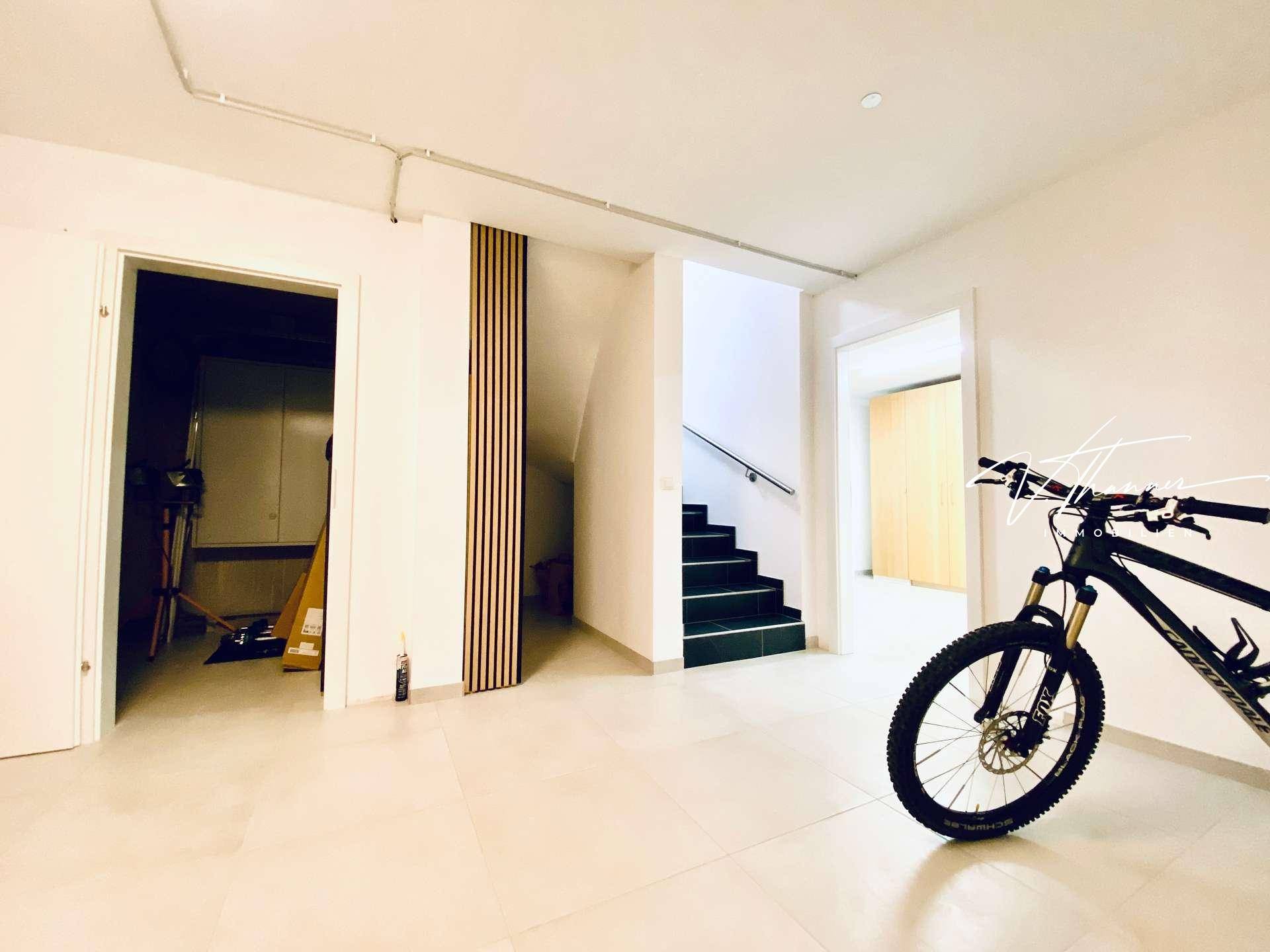 Geräumiger Eingangsbereich mit Fliesenboden, Treppe und einem Fahrrad, viel Platz.