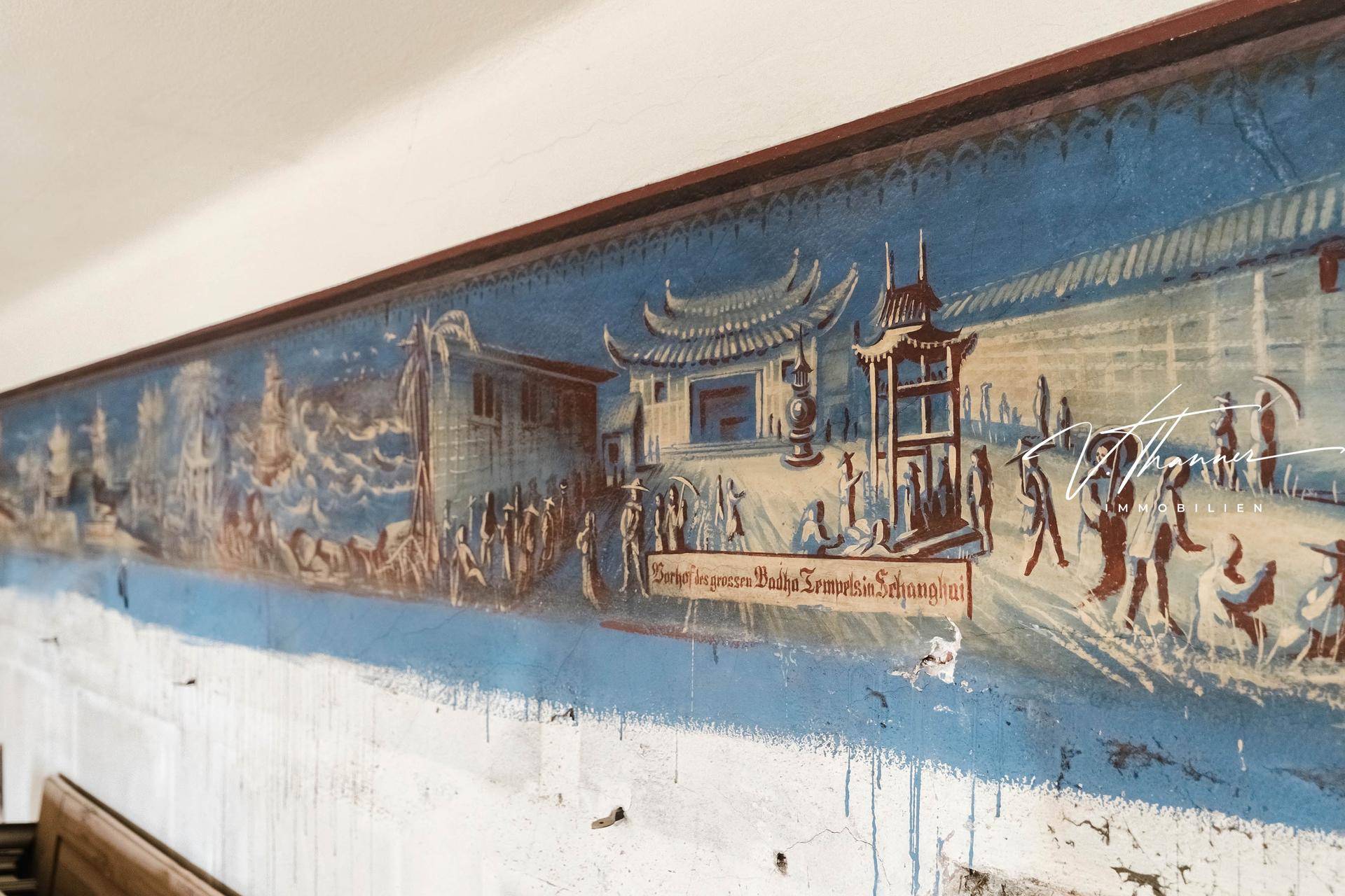 Historisches Wandgemälde mit asiatischen Motiven auf einer teilweise verputzten Wand.